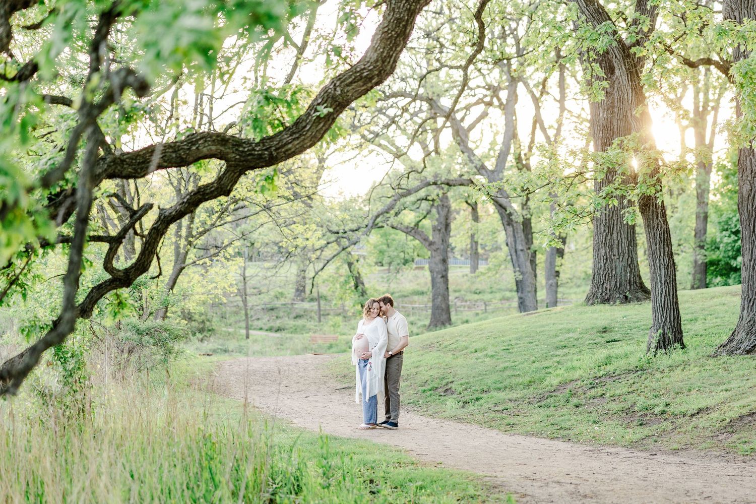 Golden hour maternity session under large trees at Veterans Acres Nature Preserve in Crystal Lake.
