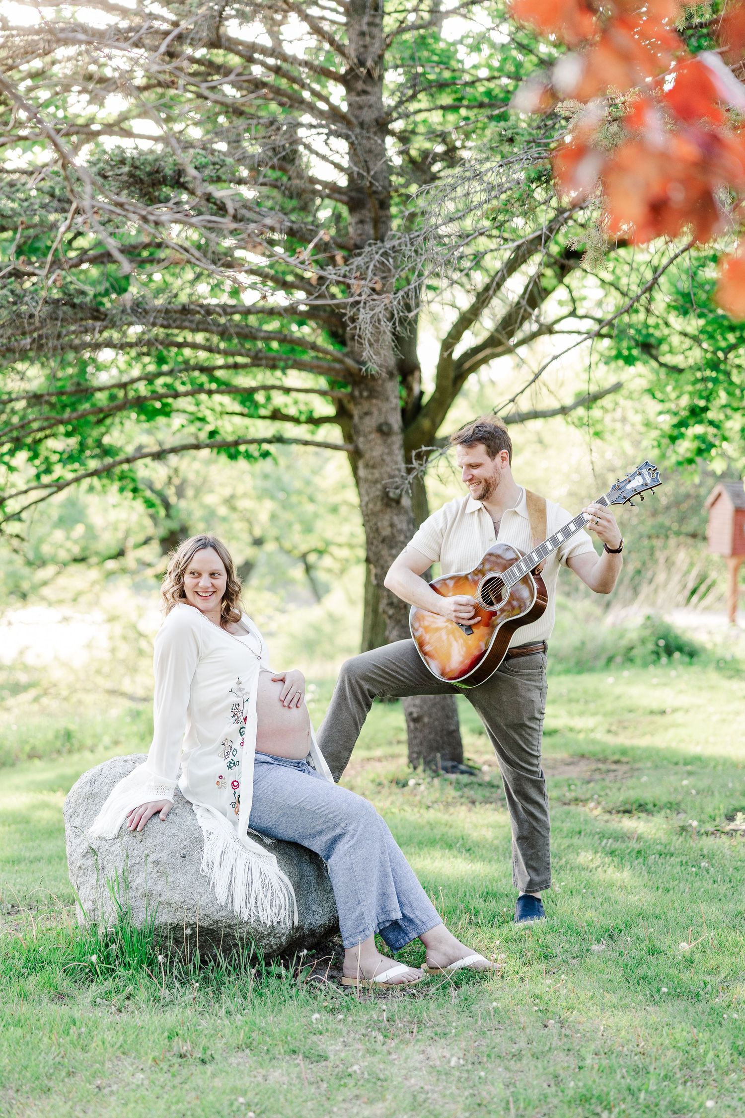 Music-inspired maternity portrait with father playing guitar for mother at Veterans Acres Nature Center in Crystal Lake, IL