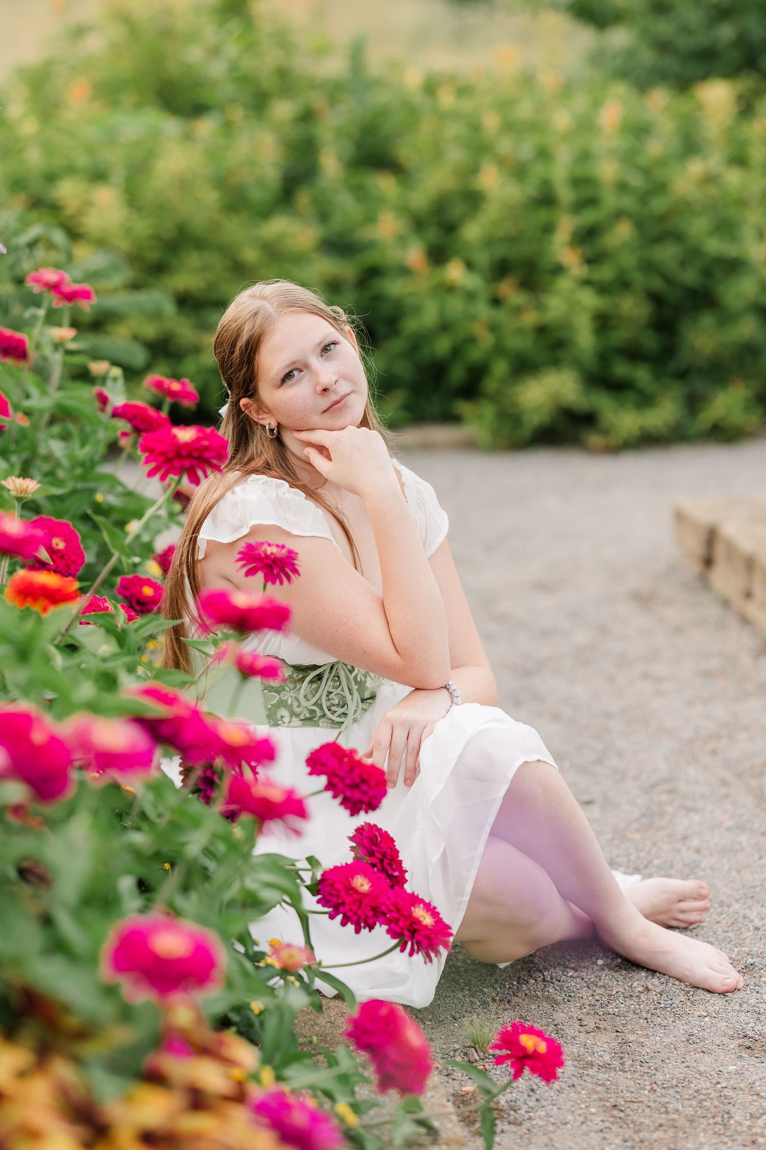 Samantha sits beside bright pink flowers during her colorful senior portrait session at Cantigny Park.