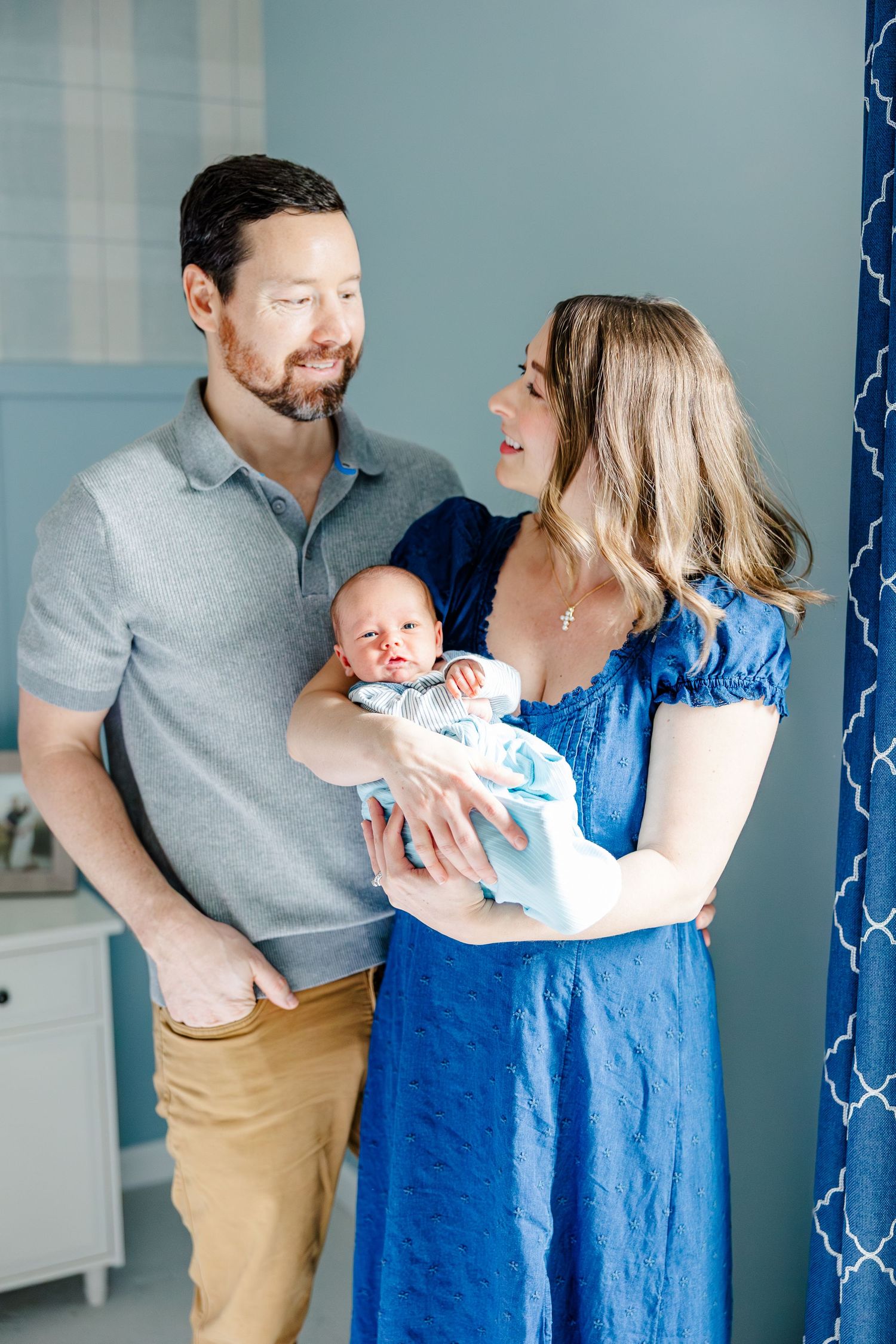 Parents holding newborn son during bright in-home lifestyle newborn session in Crystal Lake, Illinois