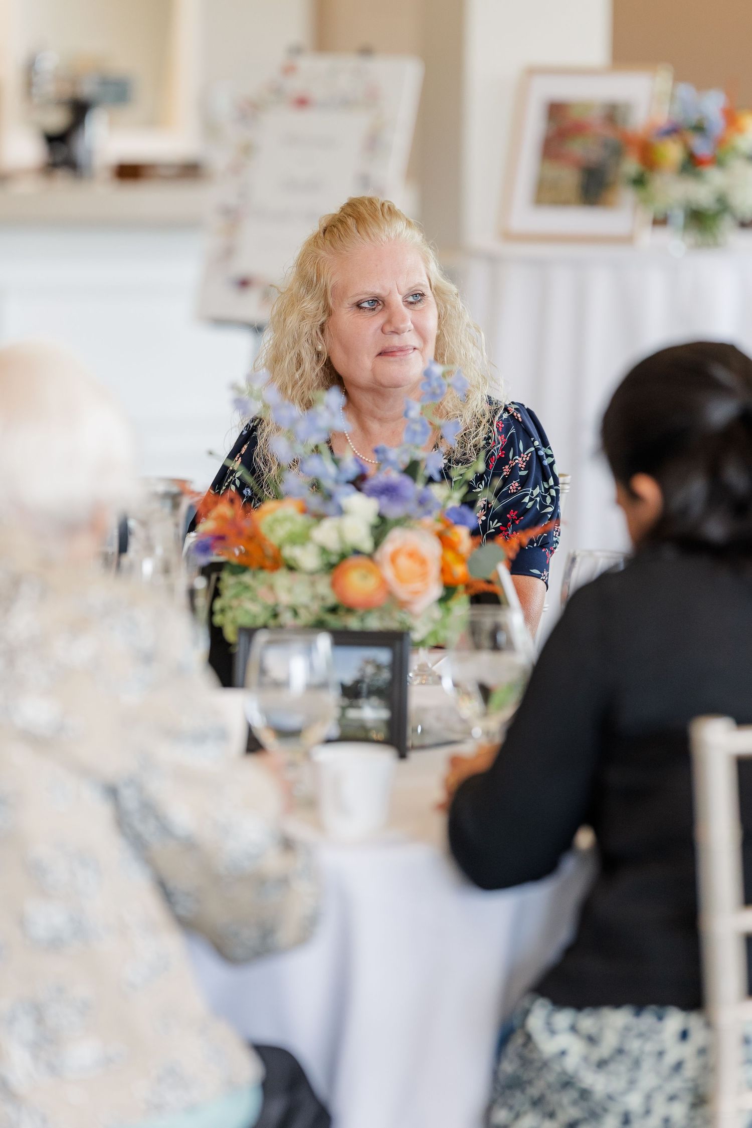 Guests chatting at floral centerpiece table during bridal shower luncheon