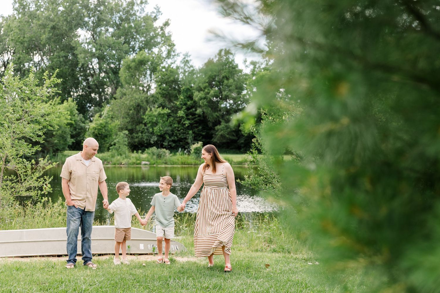 Family walking together near the lake at Shamrock Hills Park during a relaxed summer family photography session.