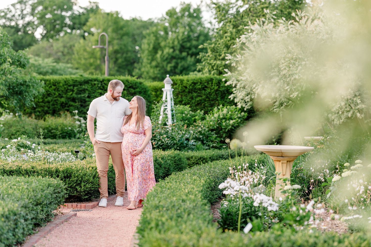 Expecting couple standing together in the formal gardens during a Cantigny maternity session in Wheaton Illinois