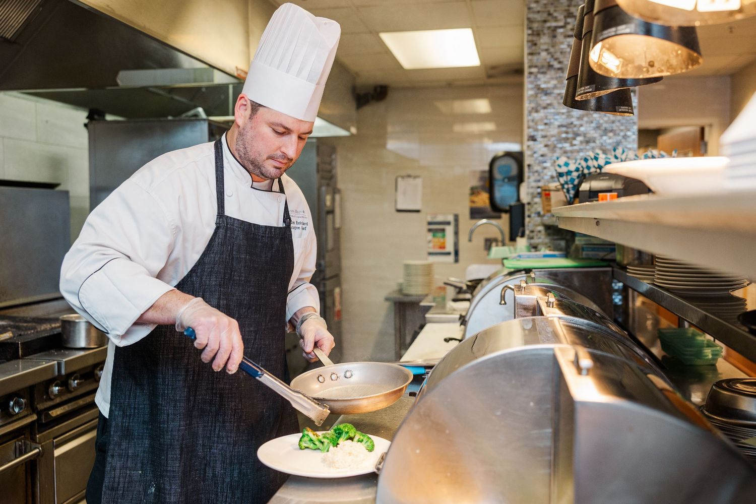 Beacon Hill senior living branding photo in Lombard, Illinois featuring chef preparing plated meal
