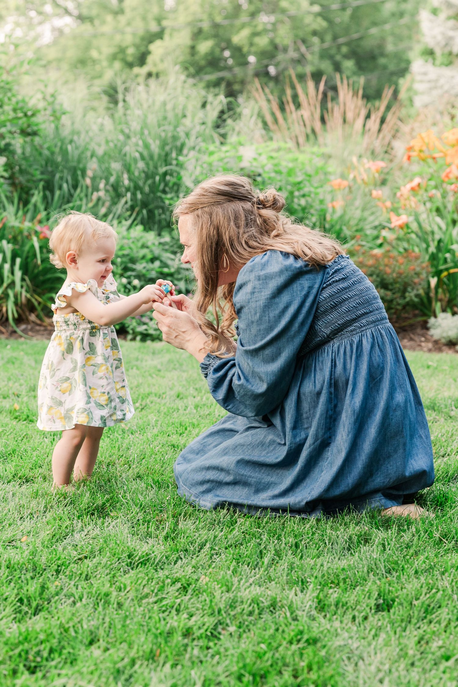 A tender moment shared in a lush garden setting on a bright summer day.