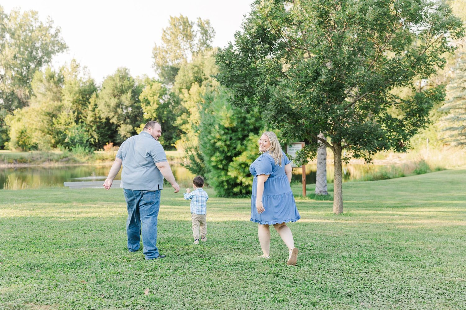 A sequence of tender moments in a sunny green park captured in soft, natural light.Sorg family portraits at Shamrock Hills Park in Crystal L