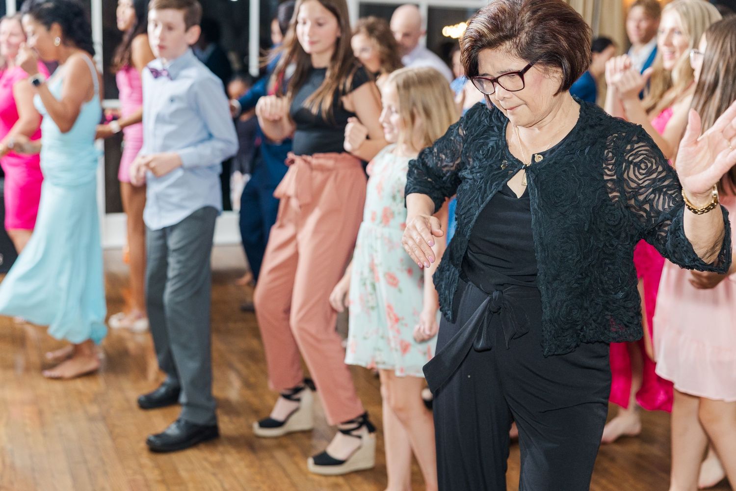 Wedding guests enjoying themselves on the dance floor during a lively reception celebration.