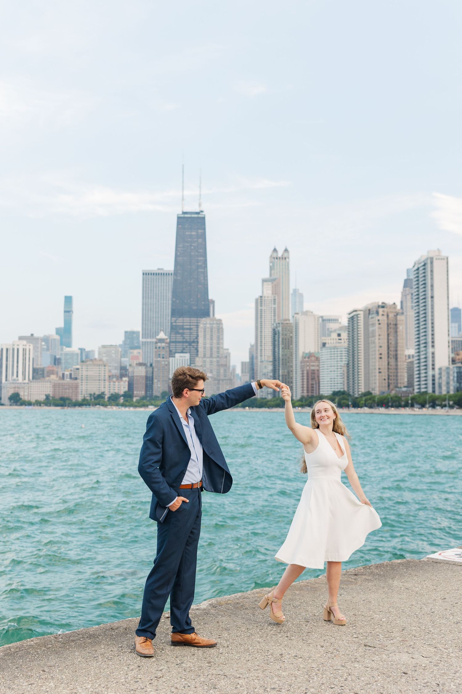 Elizabeth and Joe dancing with the Chicago skyline in the background at North Avenue Beach during sunset