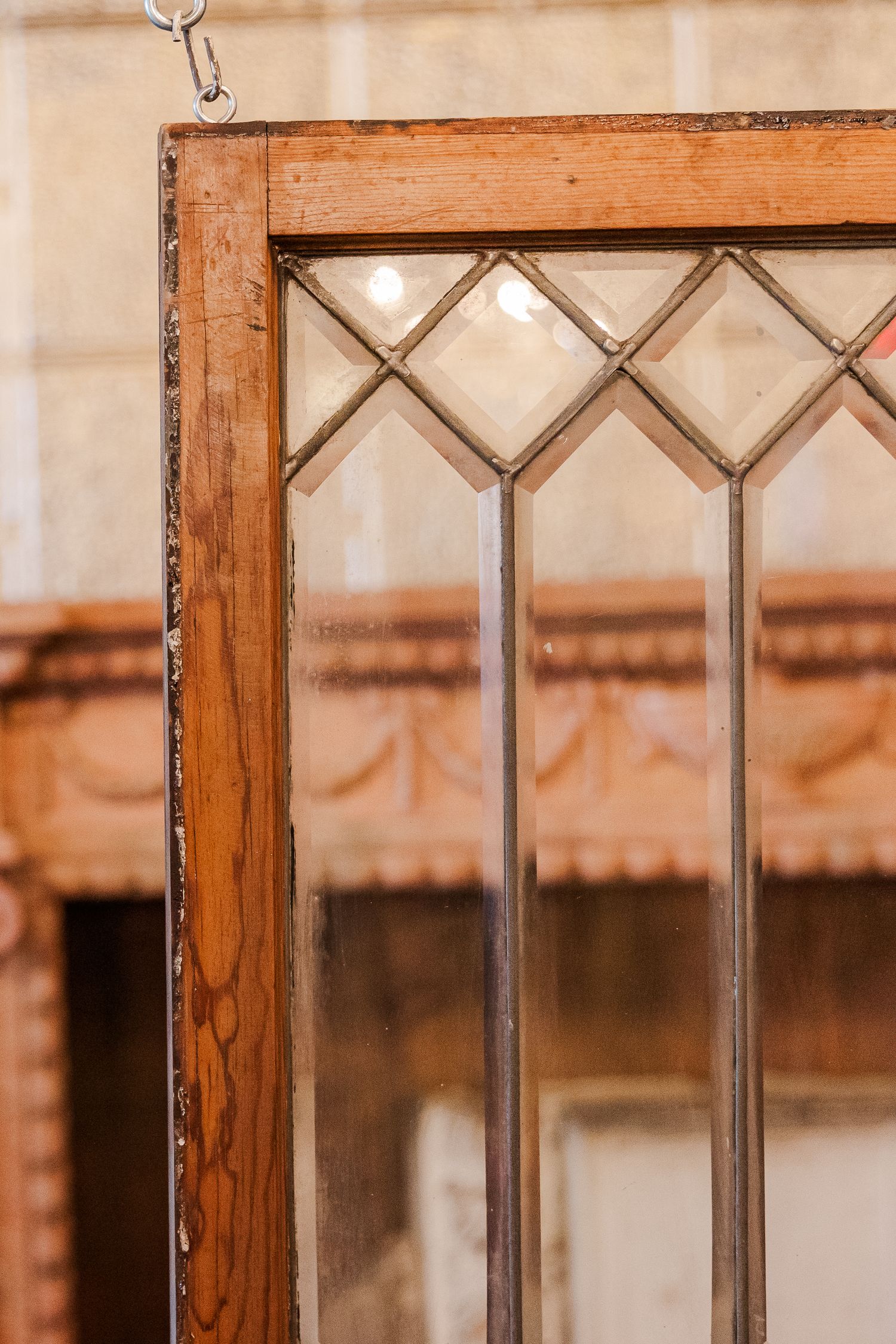 Vintage wooden window frame with geometric diamond pattern leaded glass details.