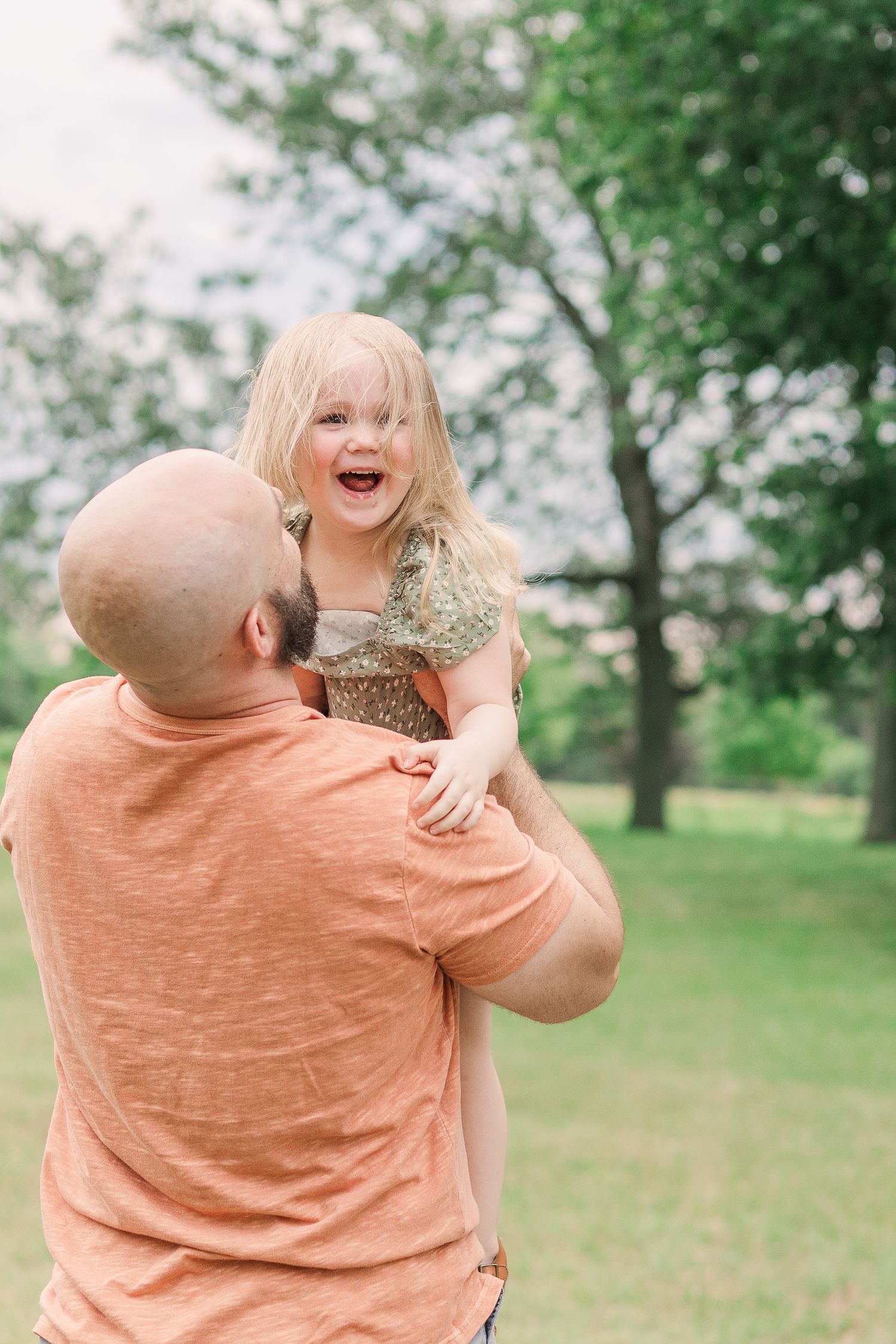 A joyful moment captured between parent and child playing outdoors in a park.