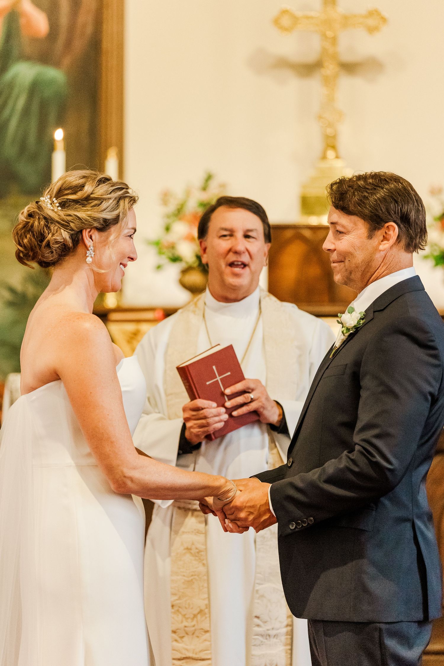 A traditional church wedding ceremony with a couple exchanging vows before an officiant at the altar.