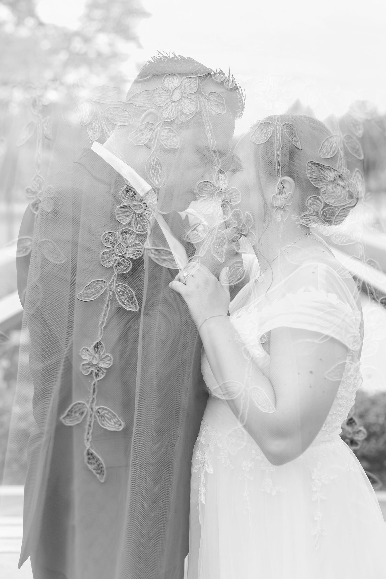 Black-and-white double-exposure portrait of Monika and Rafael with delicate floral details layered across the image.