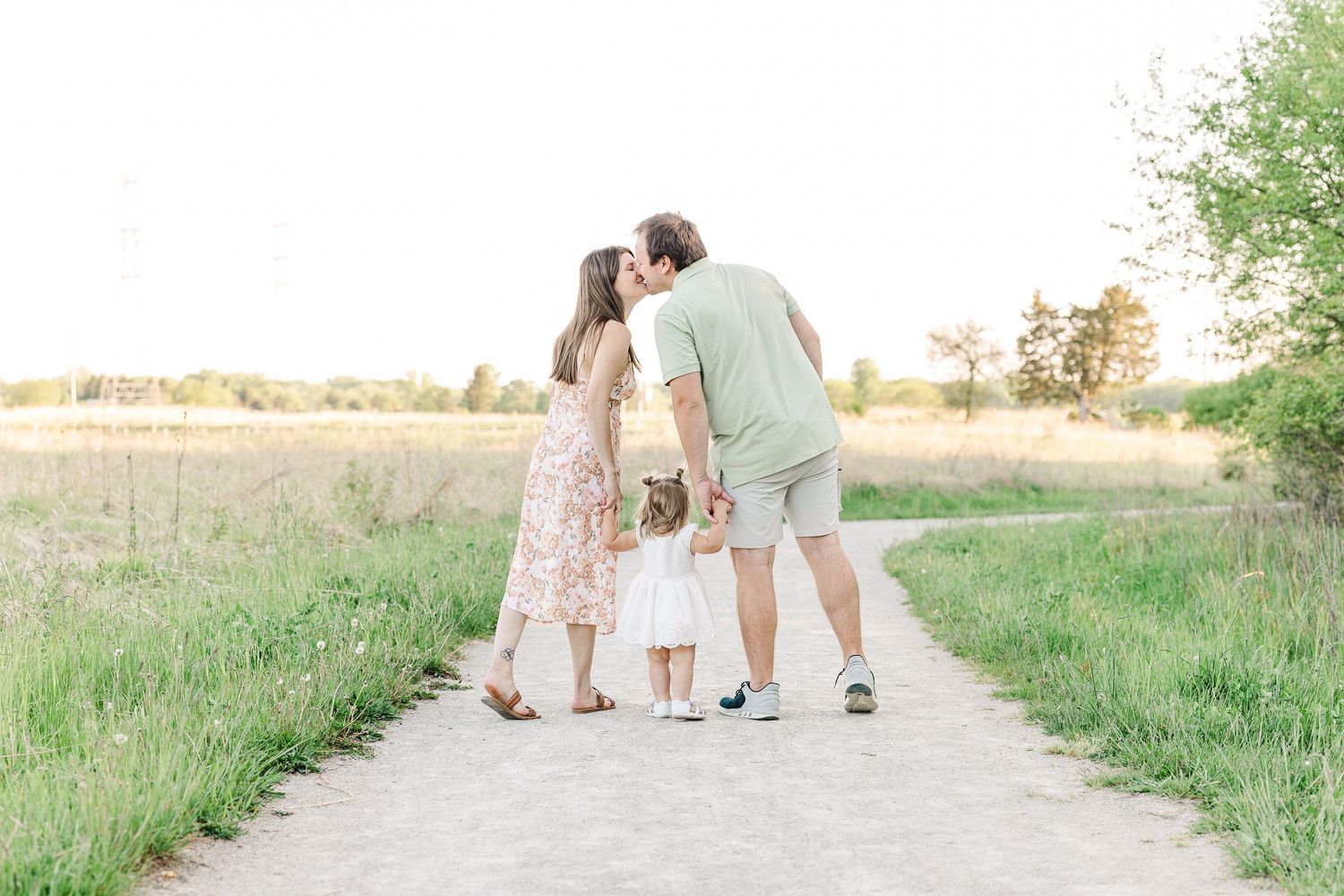 Family walking together on a rural path during golden hour.