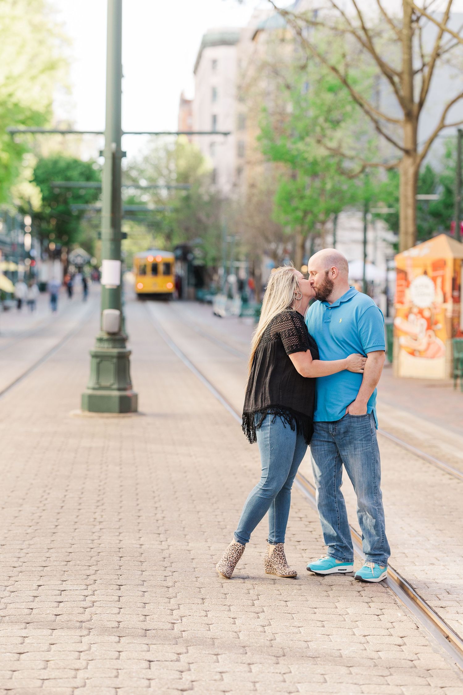A romantic moment shared between a couple on urban trolley tracks.