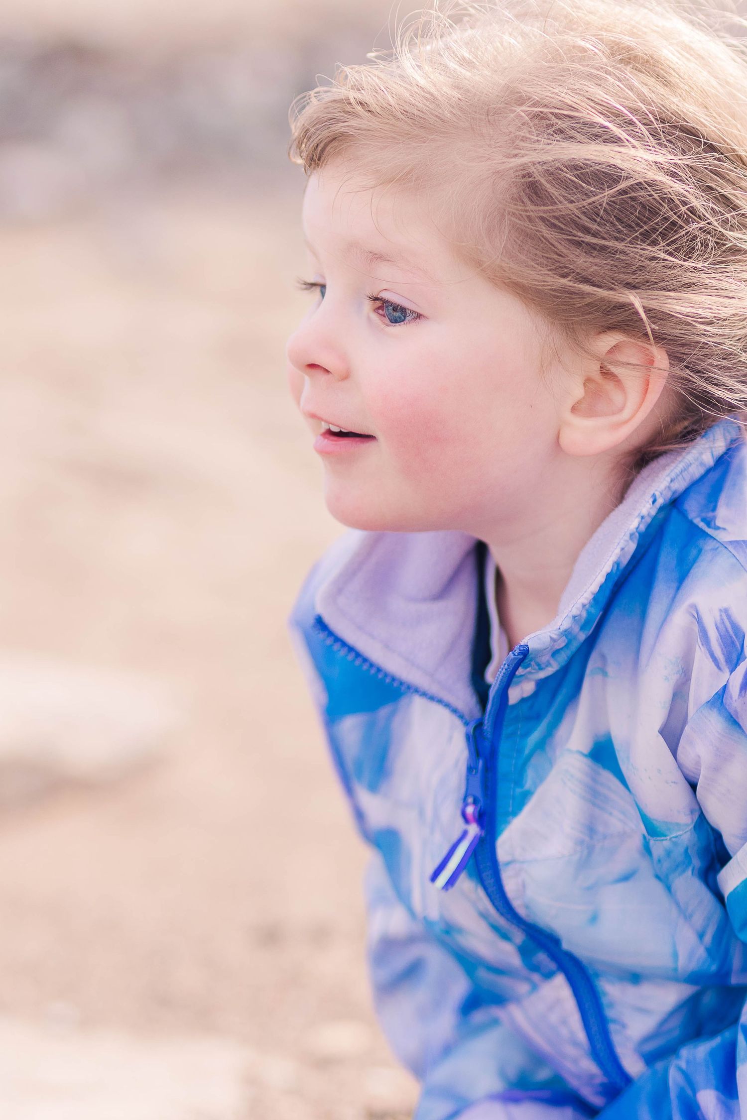 A side profile view of someone wearing a blue patterned jacket outdoors.