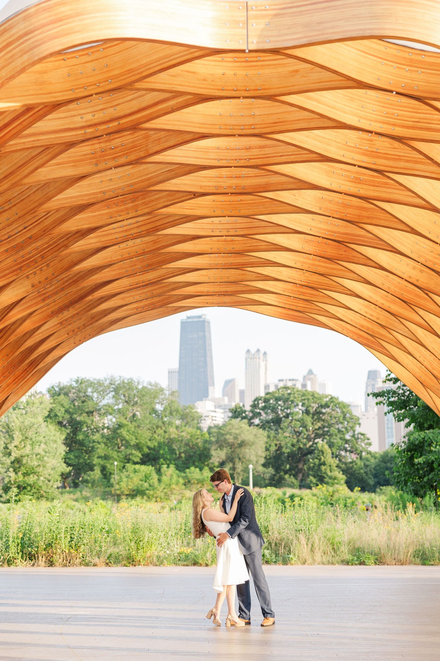 Elizabeth and Joe standing under the Honeycomb Pavilion in Lincoln Park, Chicago, dancing with each other