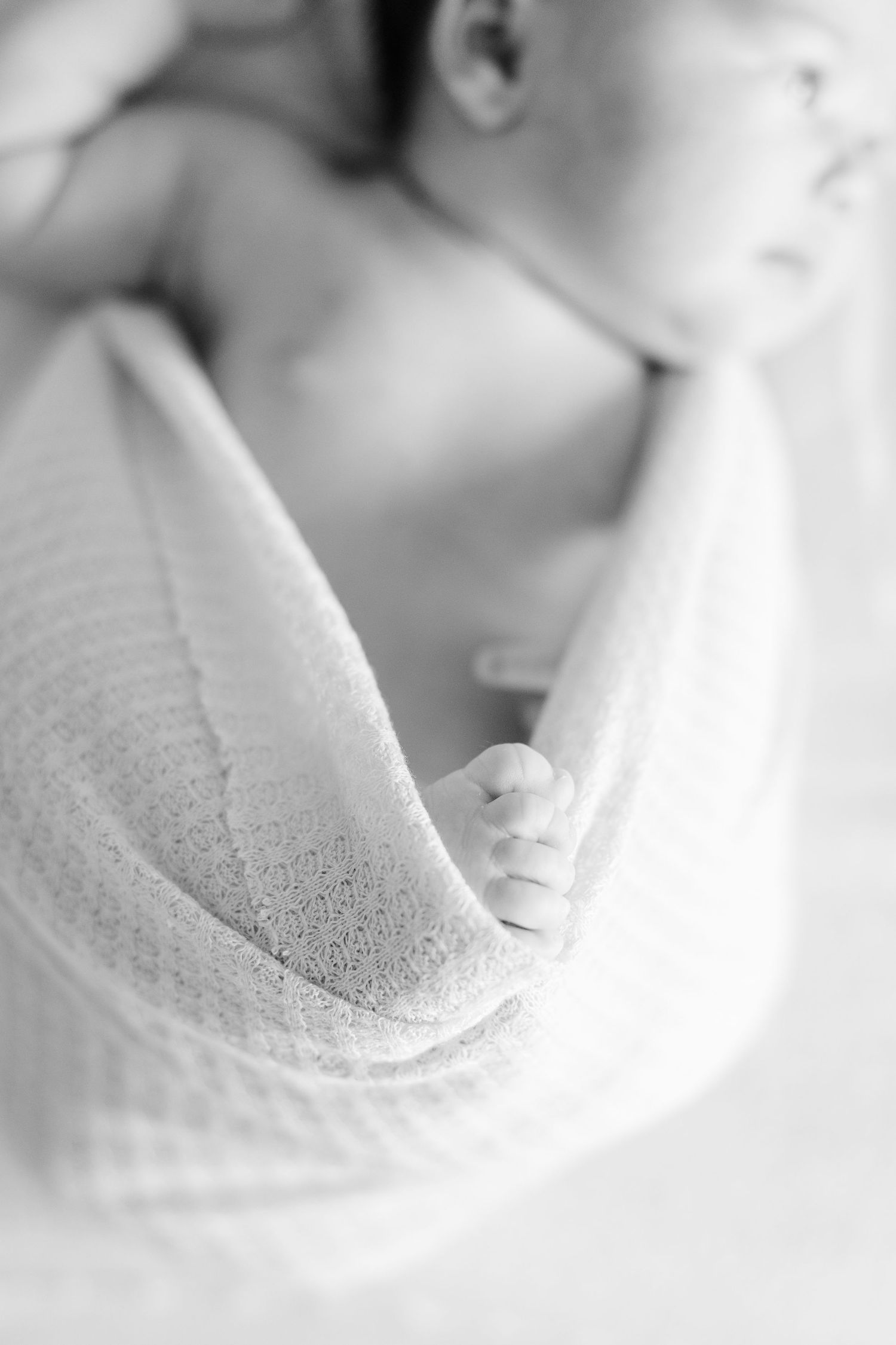 Black and white newborn detail photo during a cozy in-home lifestyle newborn session