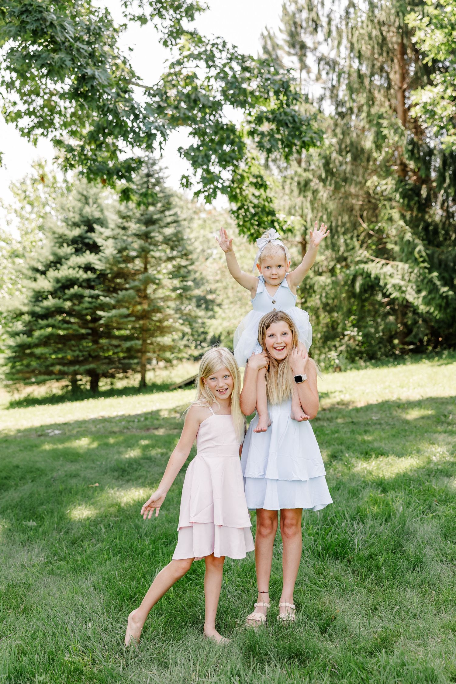 Sisters playing together in the yard during a summer family portrait session in Crystal Lake, Illinois.