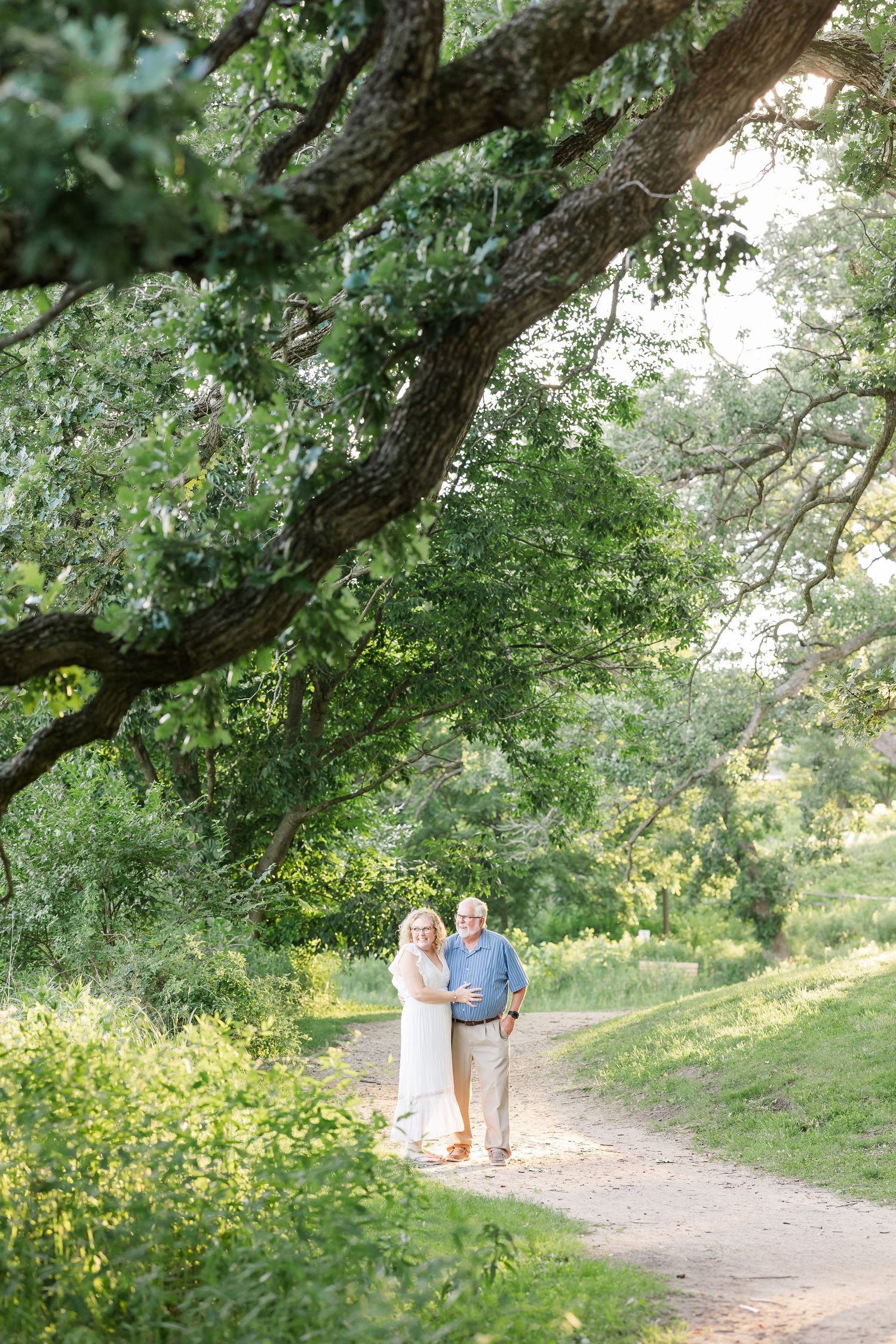 Grandparents walking under the trees during an outdoor extended family session at Veterans Acres Nature Center