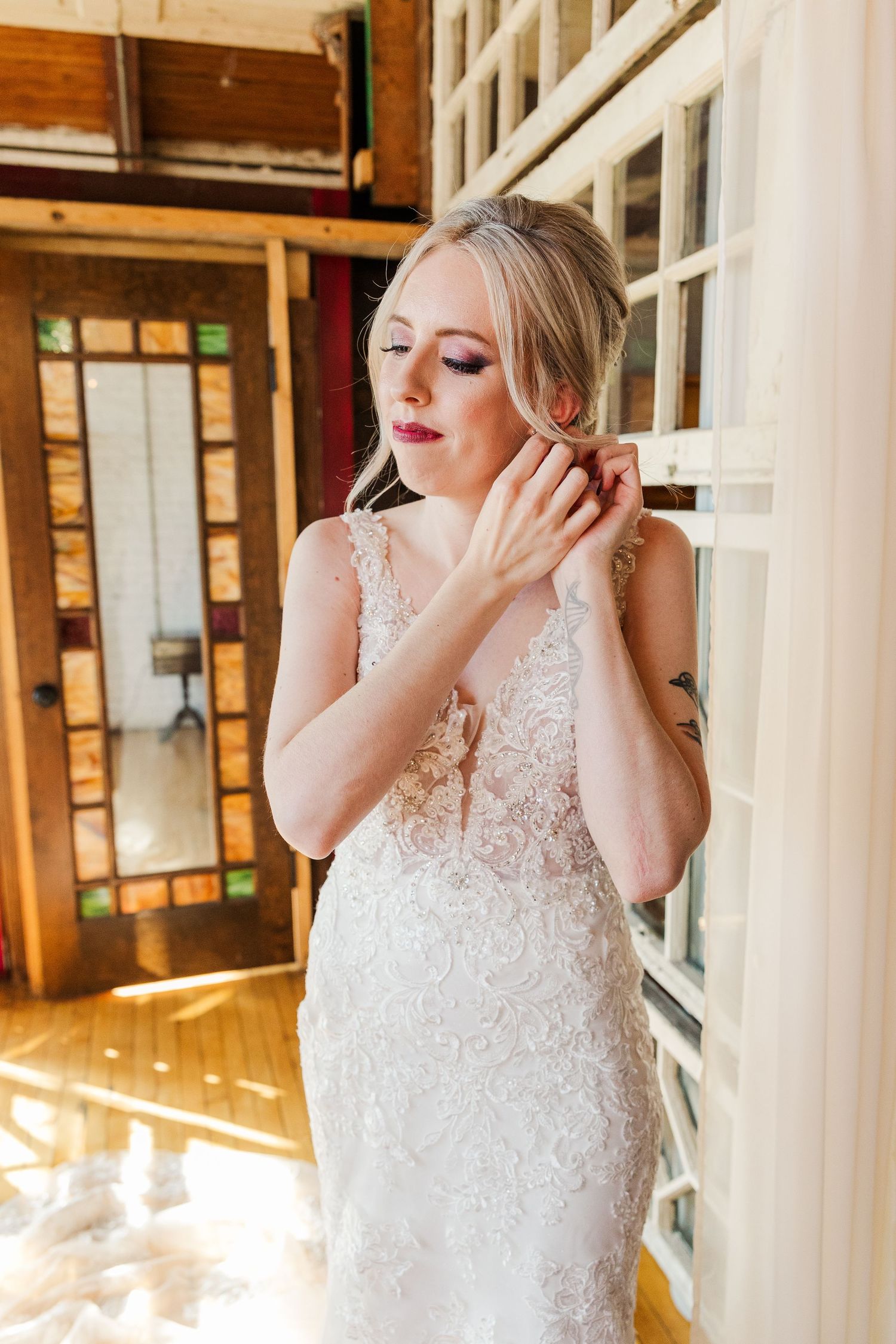 Elegant lace wedding dress captured in natural window light.