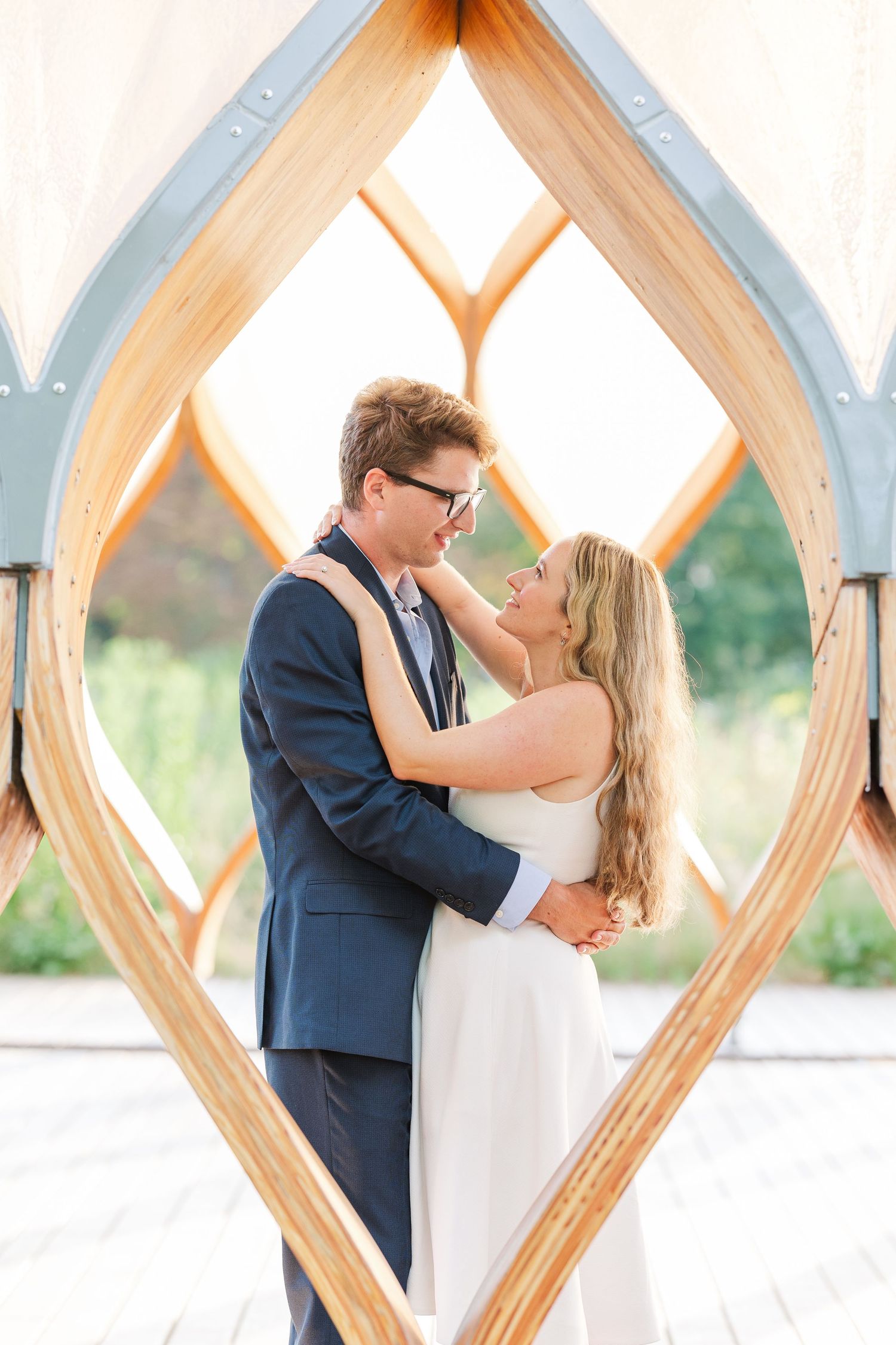 Elizabeth and Joe standing under the Honeycomb Pavilion in Lincoln Park, Chicago, smiling at each other