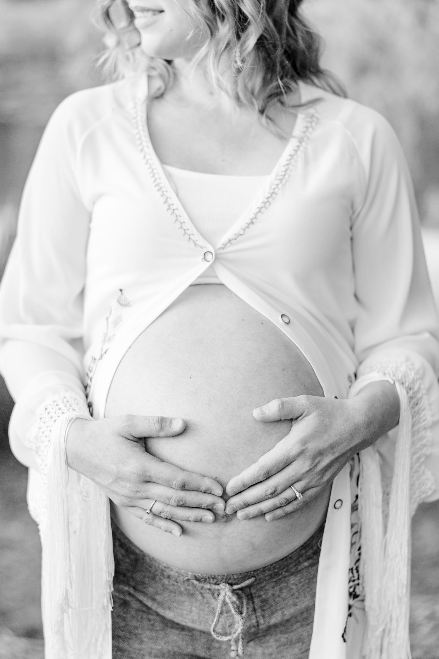 Black and white maternity portrait of mother holding baby bump at Veterans Acres Nature Preserve.