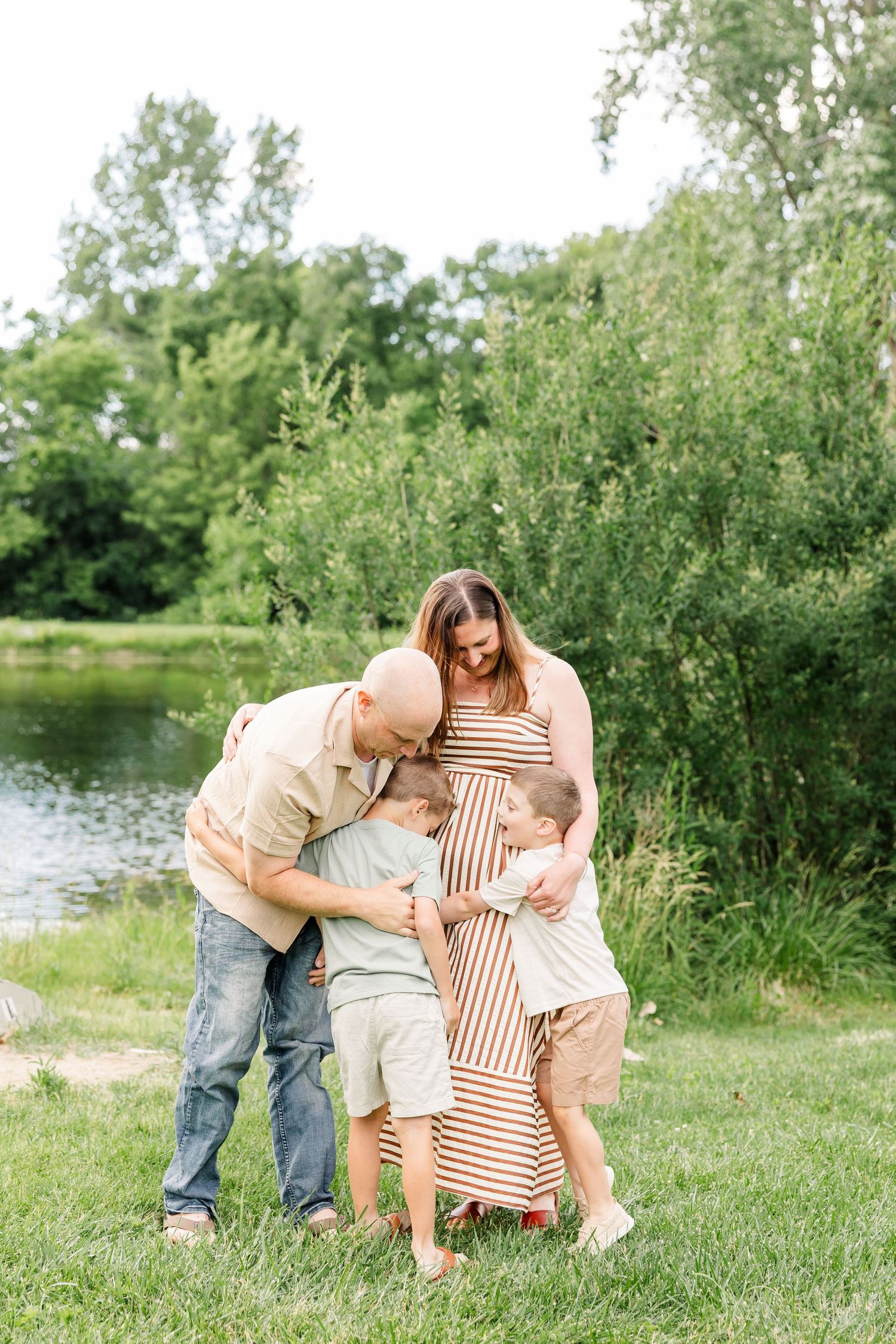 Parents snuggling their young son during a playful family portrait session in Crystal Lake, Illinois.