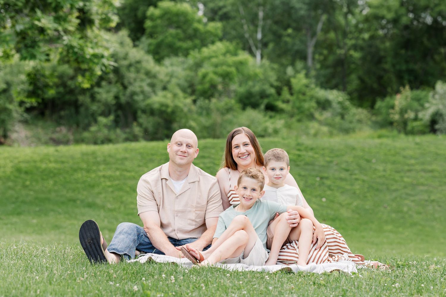 Family of four sitting together on a blanket during a relaxed family photography session in Crystal Lake.