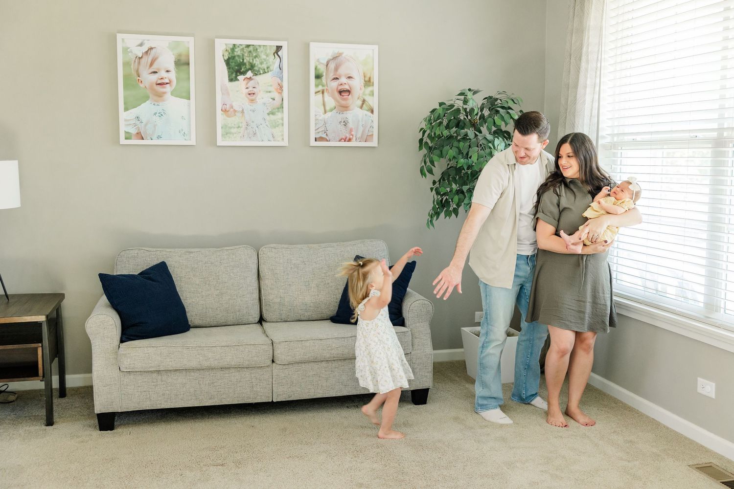 Family enjoying a relaxed lifestyle newborn session at home with big sister dancing nearby