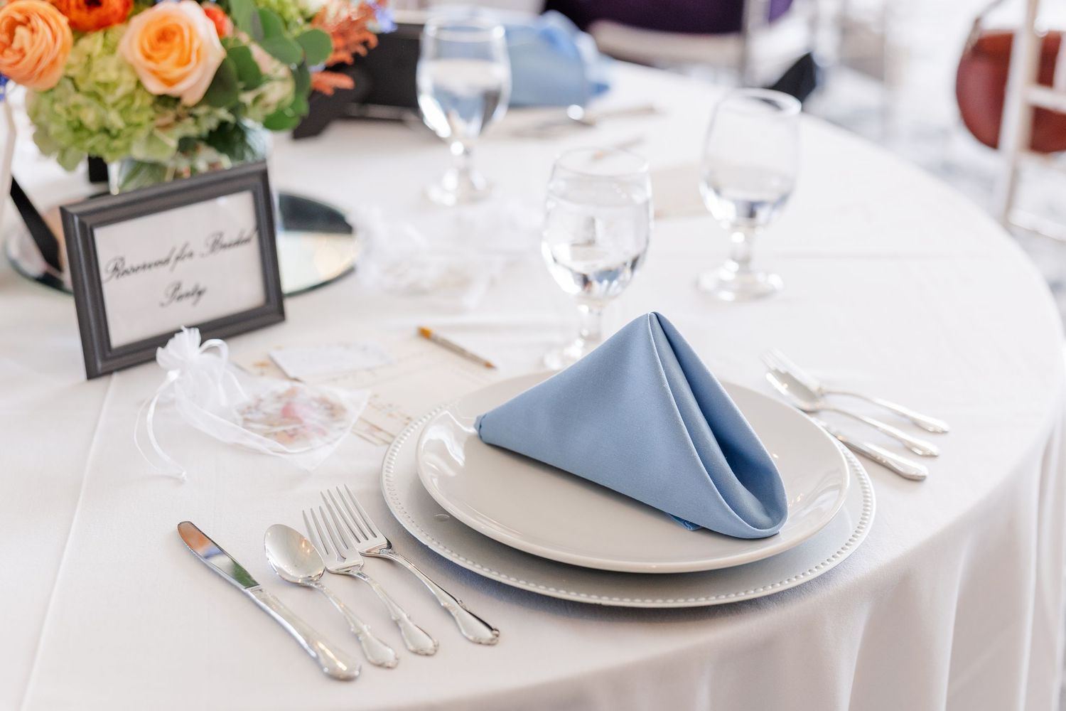 Elegant place setting with blue napkin and floral card at bridal shower