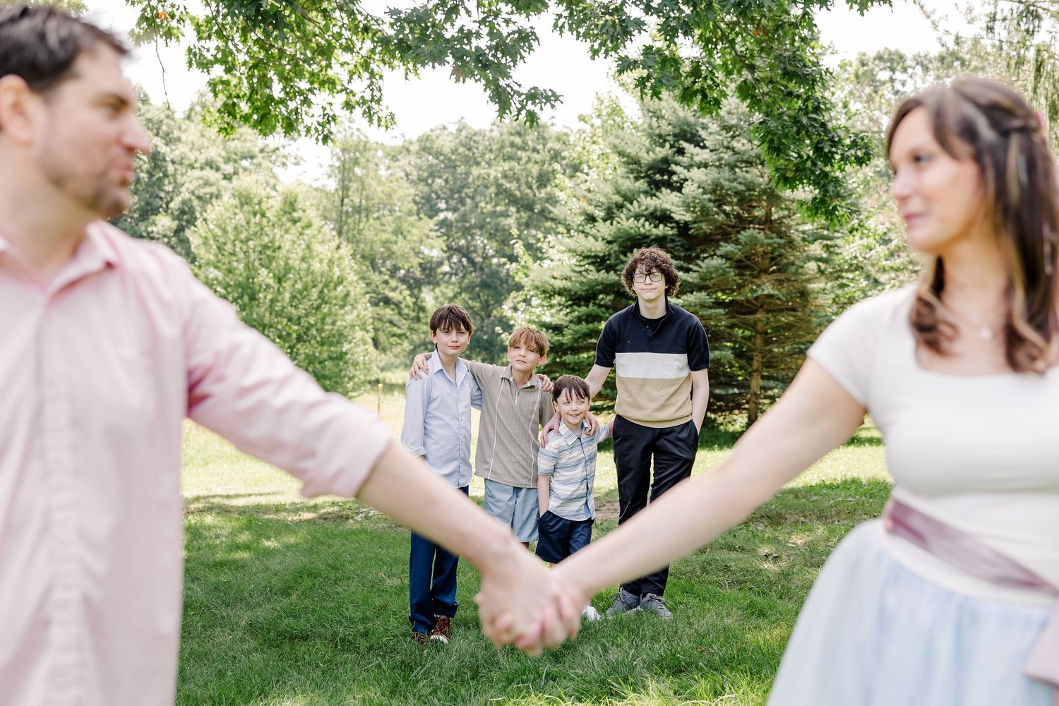Close-up of a couple holding hands during a relaxed outdoor family session in Crystal Lake, Illinois.