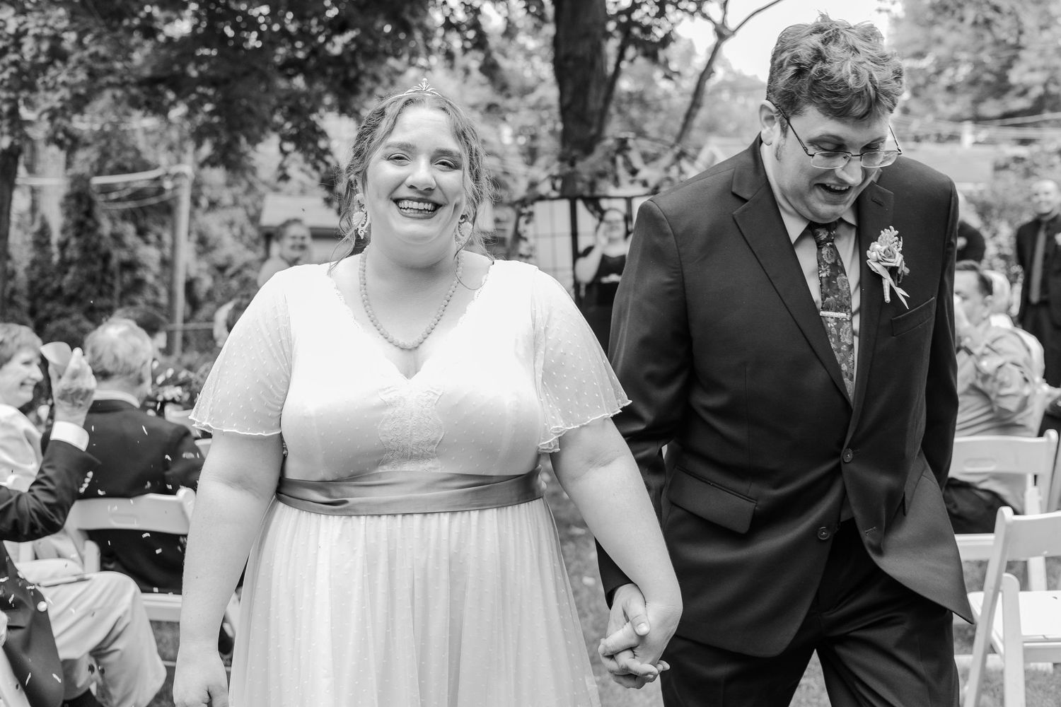 Wedding ceremony scene with couple walking down the aisle outdoors.