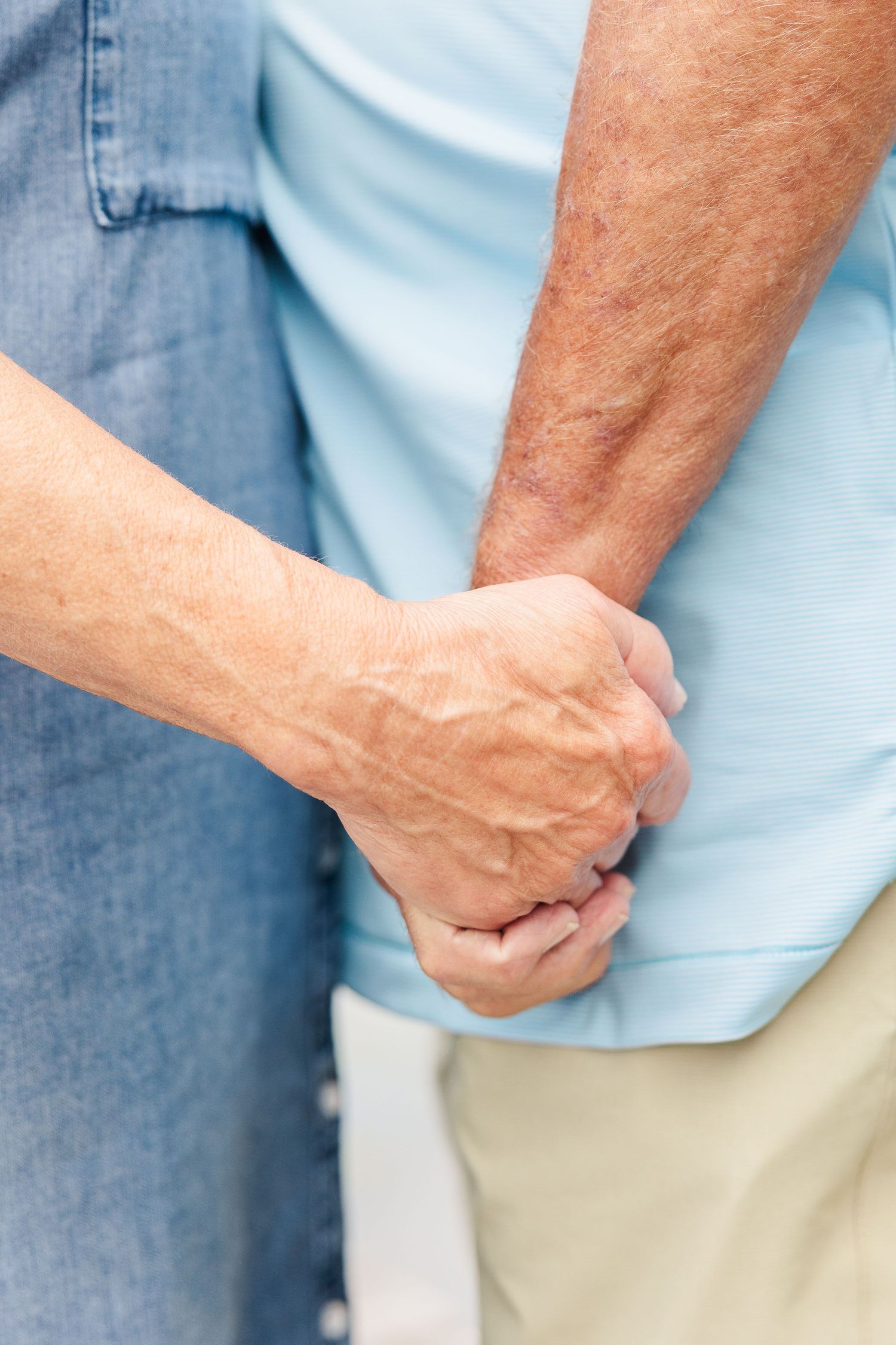 Close-up shot of hands clasped together showing connection and intimacy.