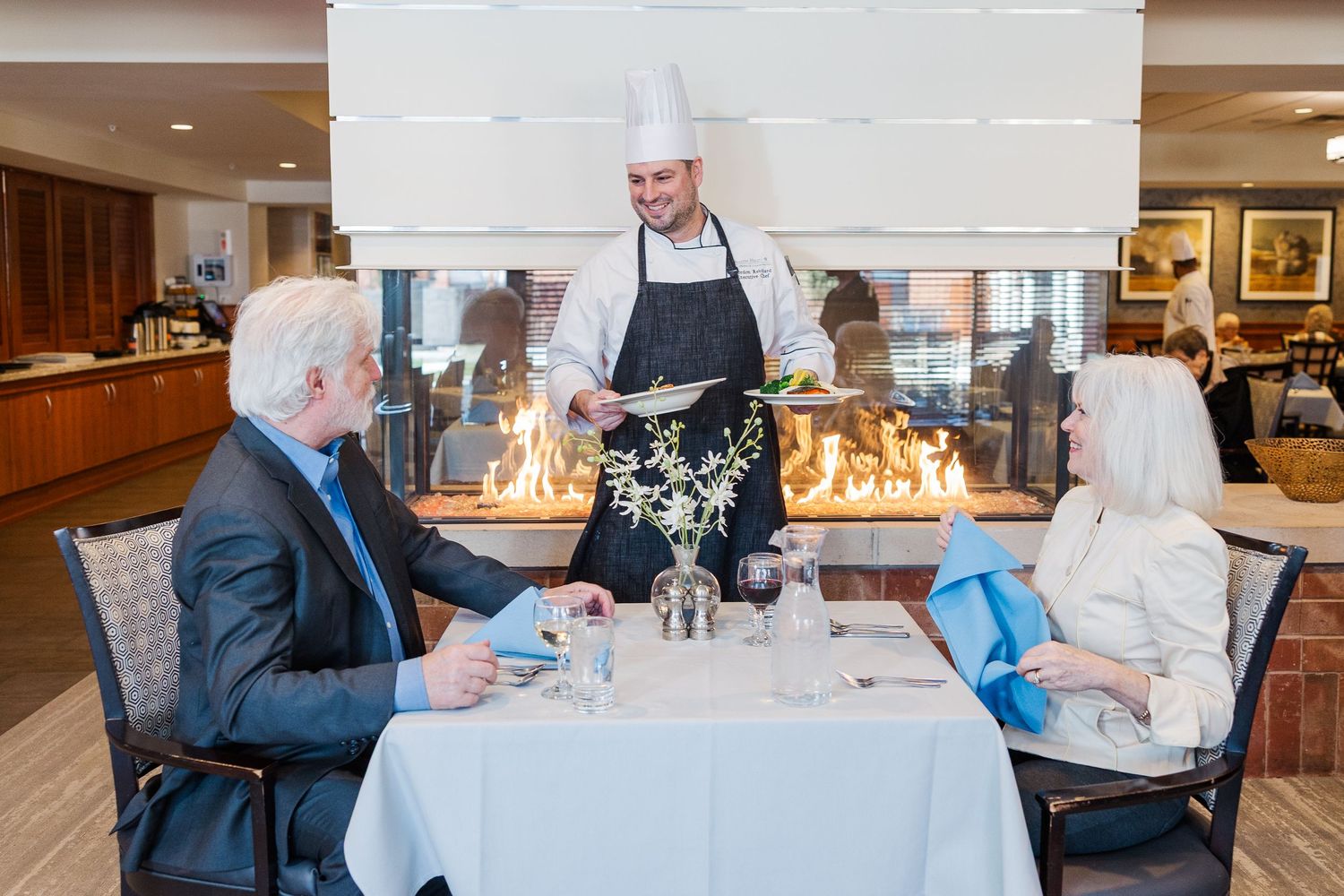 Beacon Hill senior living branding photo in Lombard, Illinois featuring residents dining with chef