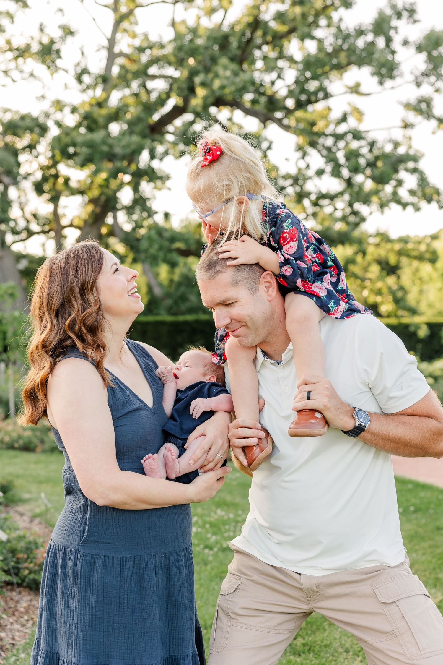 Caroline riding on Andrew’s shoulders as Hilary holds newborn Lincoln during their family portraits.