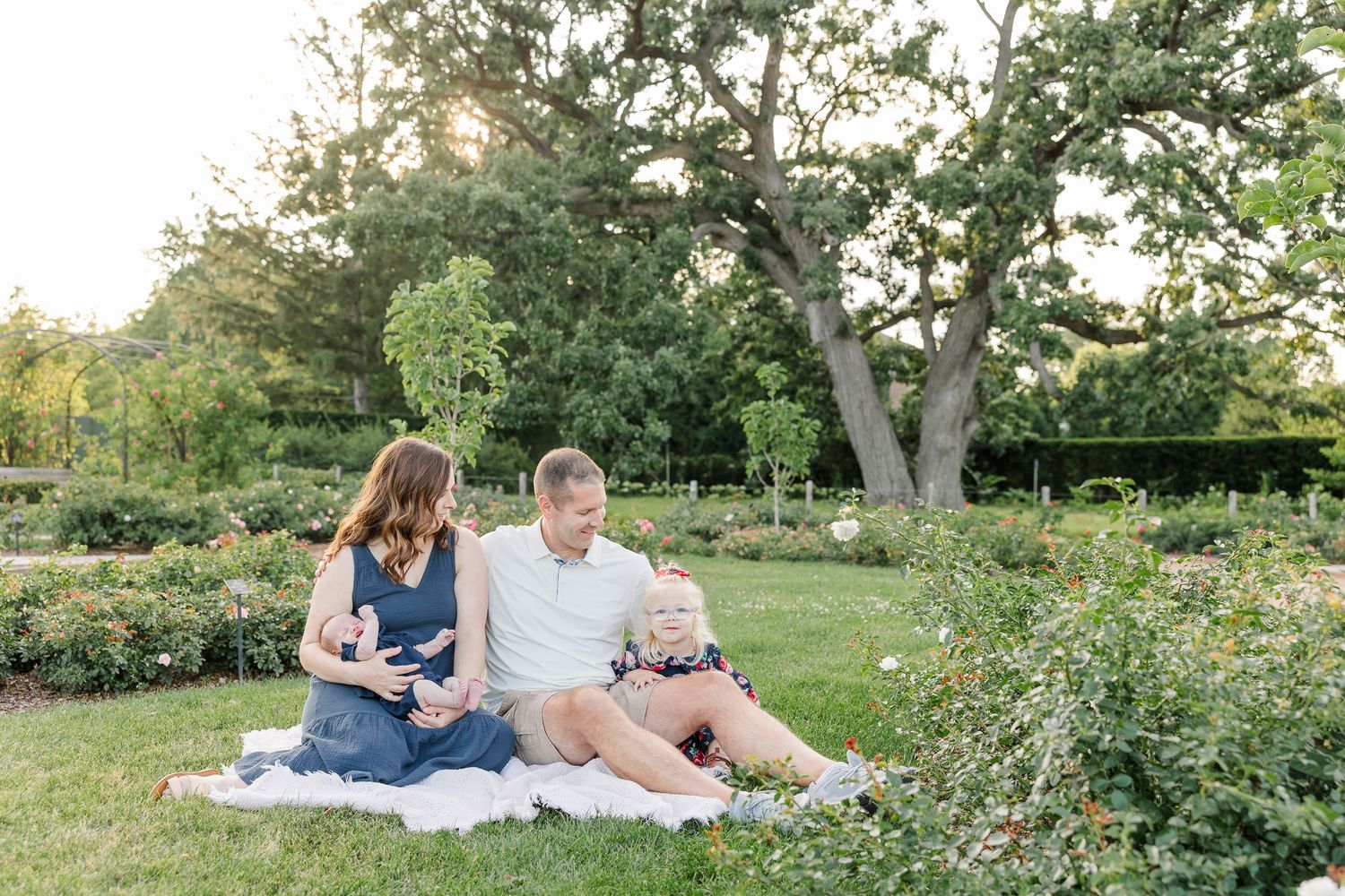 The Lawler family sharing a relaxed moment on a blanket among the gardens at Cantigny Park.