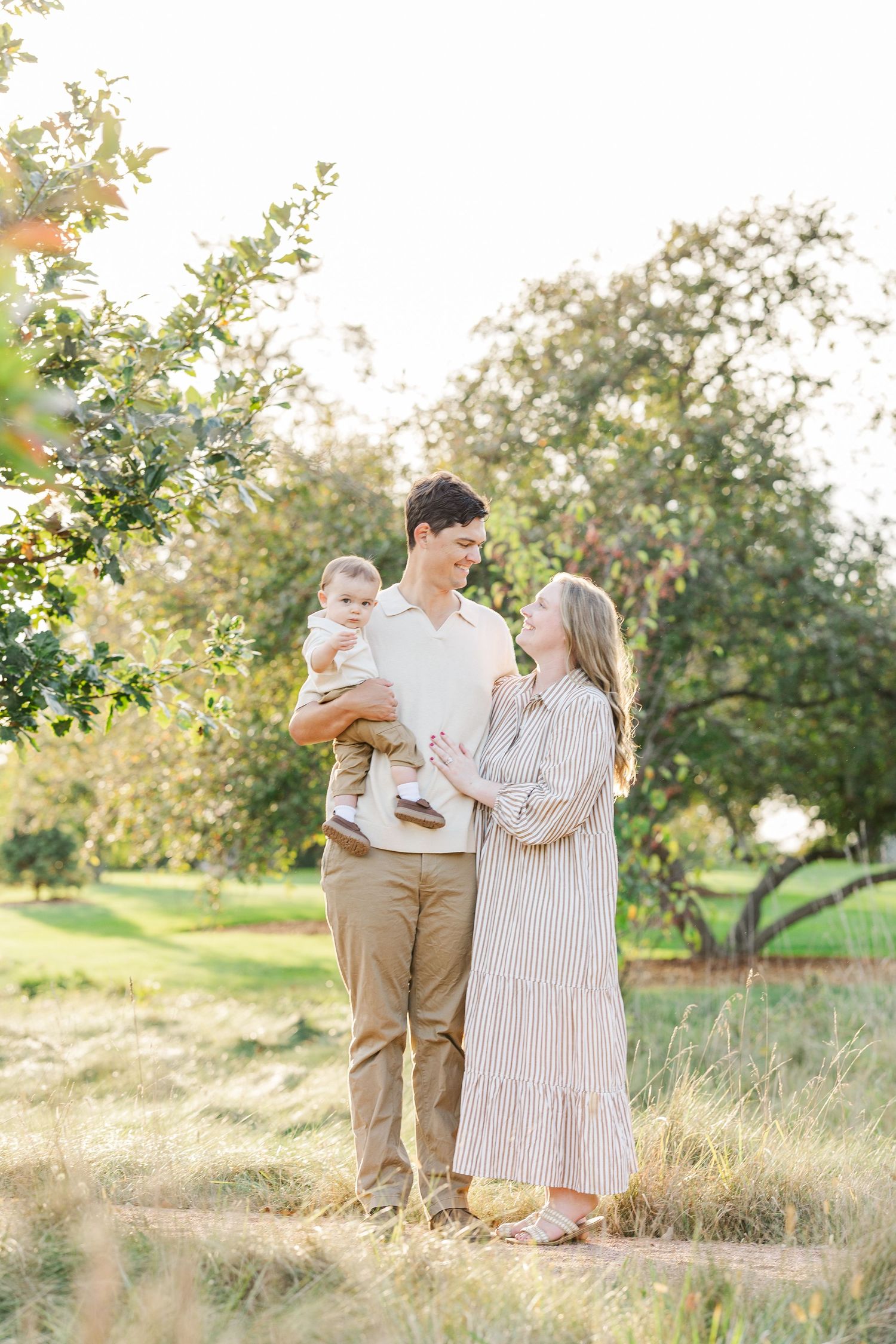Family portrait session at Cantigny Park Wheaton IL with parents and baby walking in natural light.