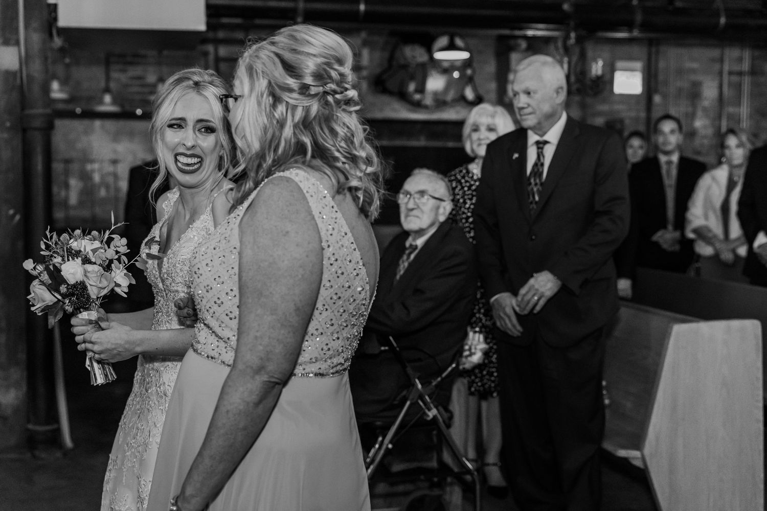 Joy and laughter during a wedding ceremony in black and white photography.