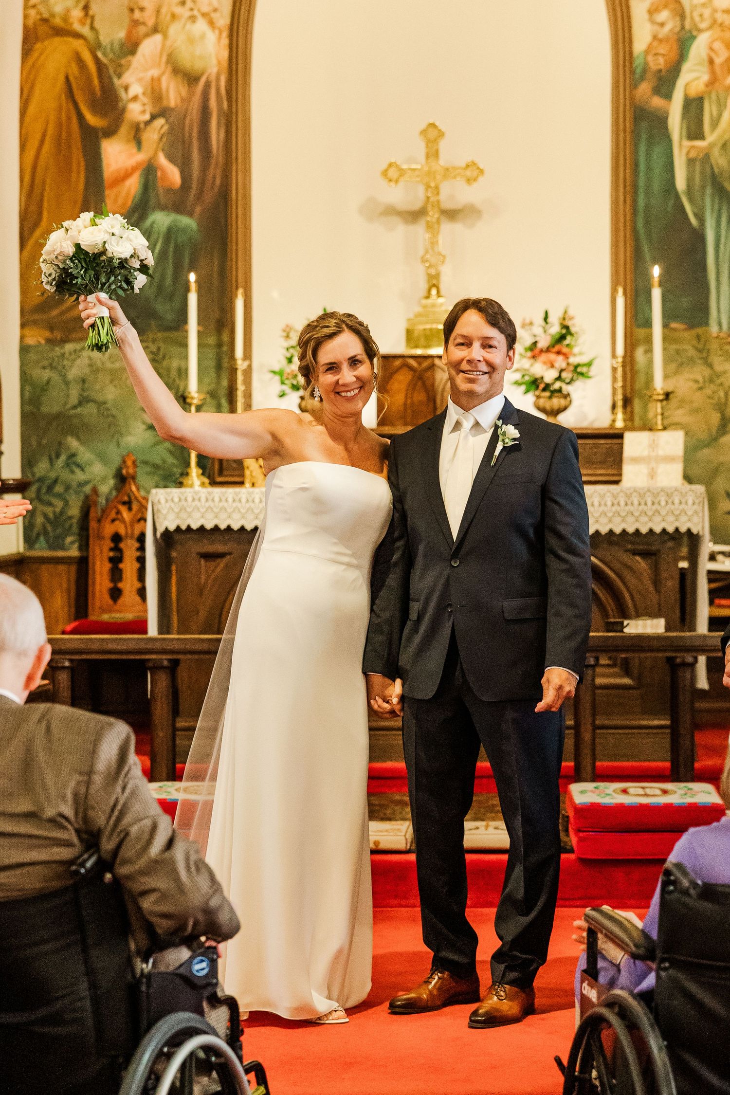 Wedding celebration in traditional church with religious artwork and wheelchair-accessible seating.