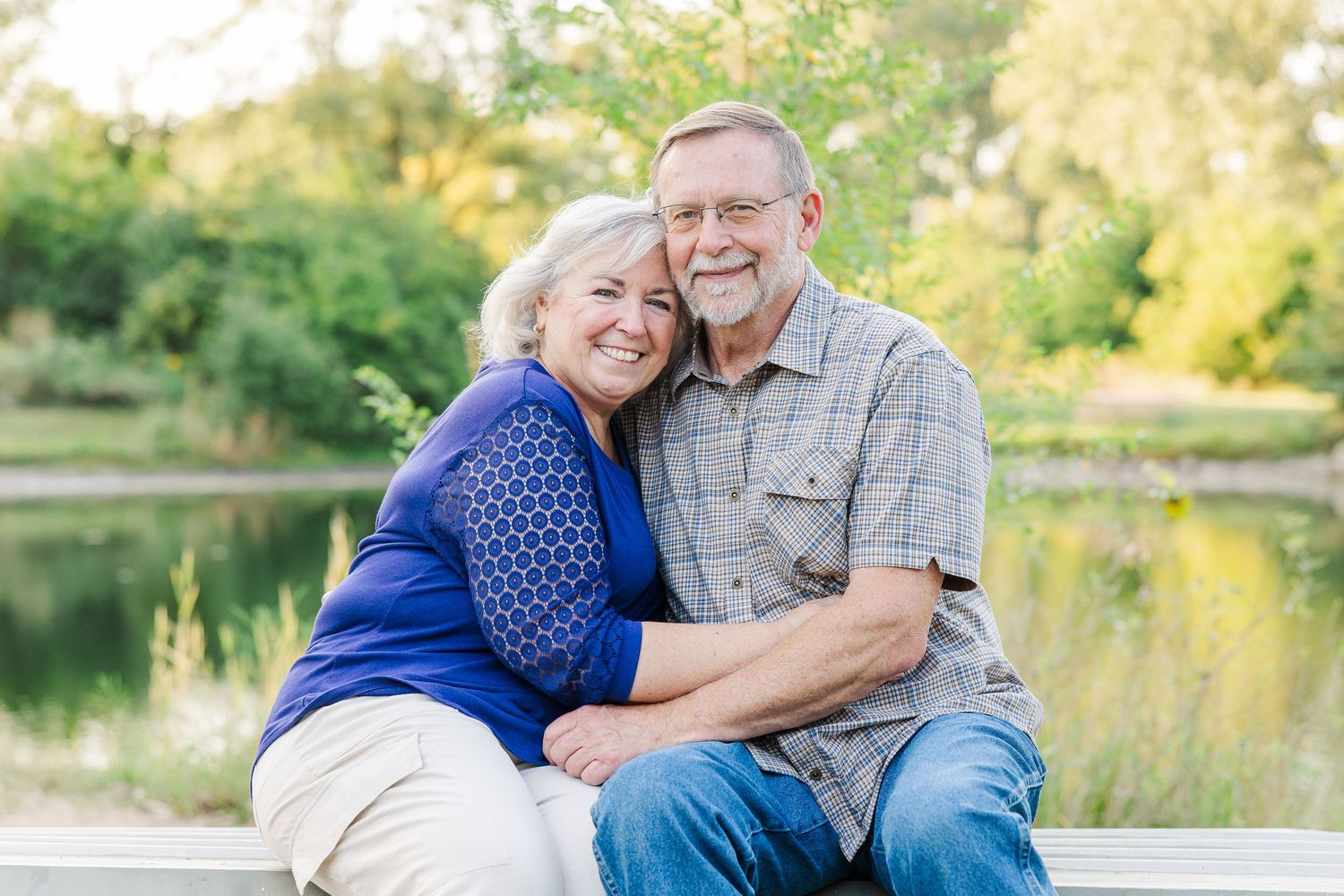 A series of outdoor family photos featuring a couple posing together in casual attire by a lake during golden hour.Sorg family portraits at