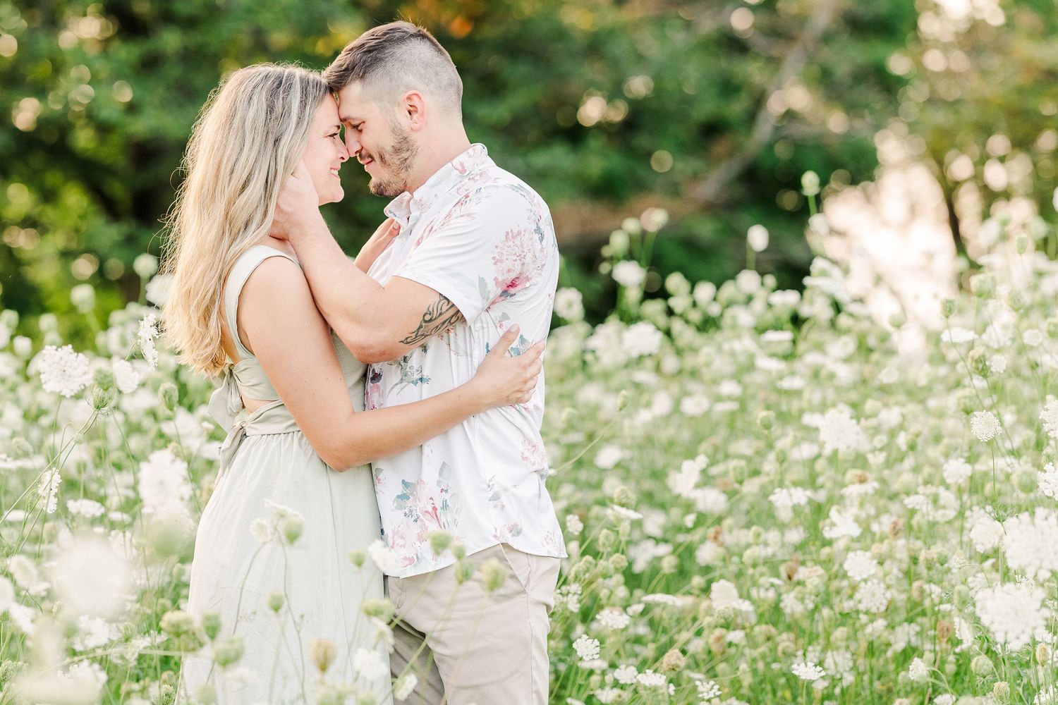 Intimate portrait of couple in love surrounded by wildflowers at sunset.