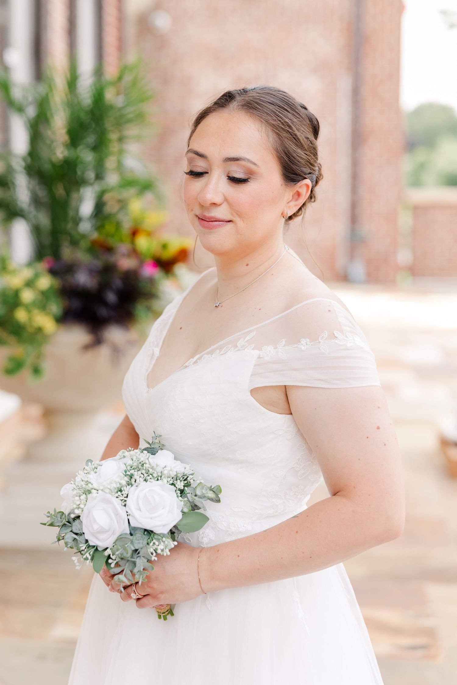 Monika holding her white rose bouquet beneath the columns at McCormick House in Cantigny Park.