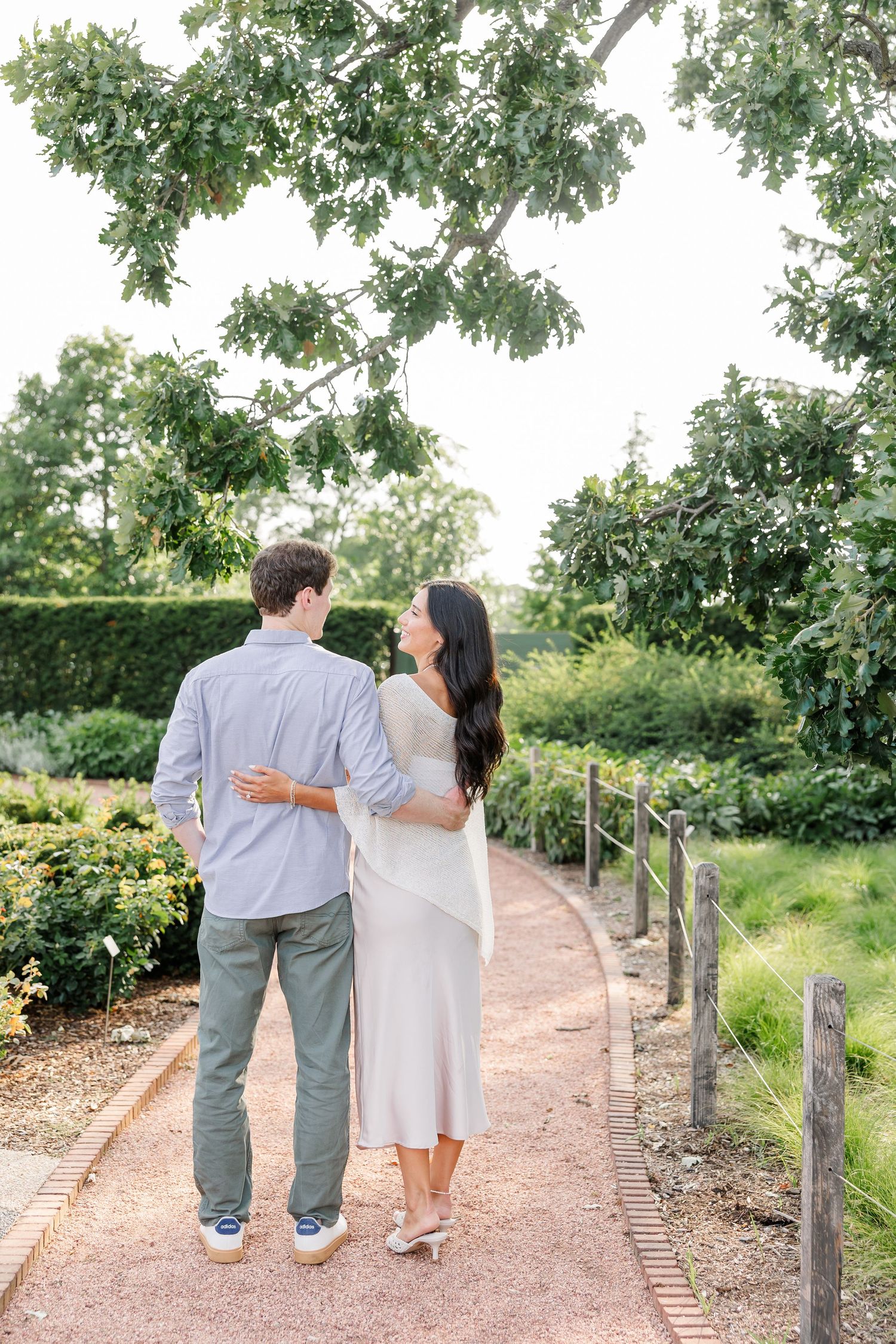 Alysia and Jack walk arm in arm through the Cantigny Park gardens after their proposal.
