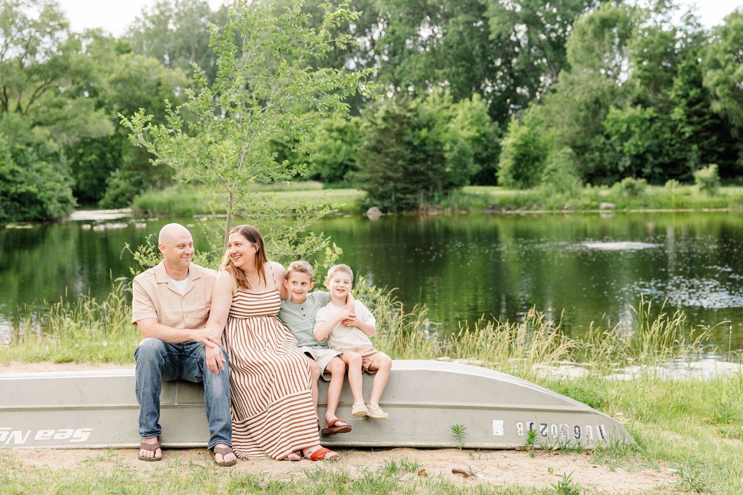 Family sitting together near the water during a natural family photography session in Crystal Lake, Illinois.