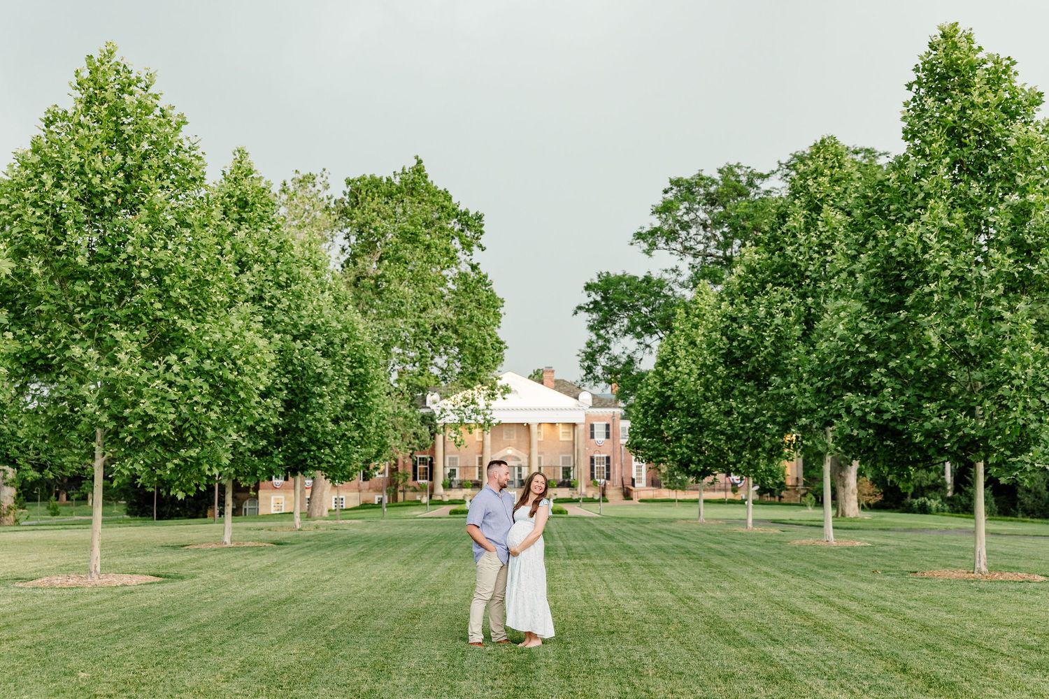 Wide maternity portrait of expecting parents on the lawn at Cantigny Park in Wheaton