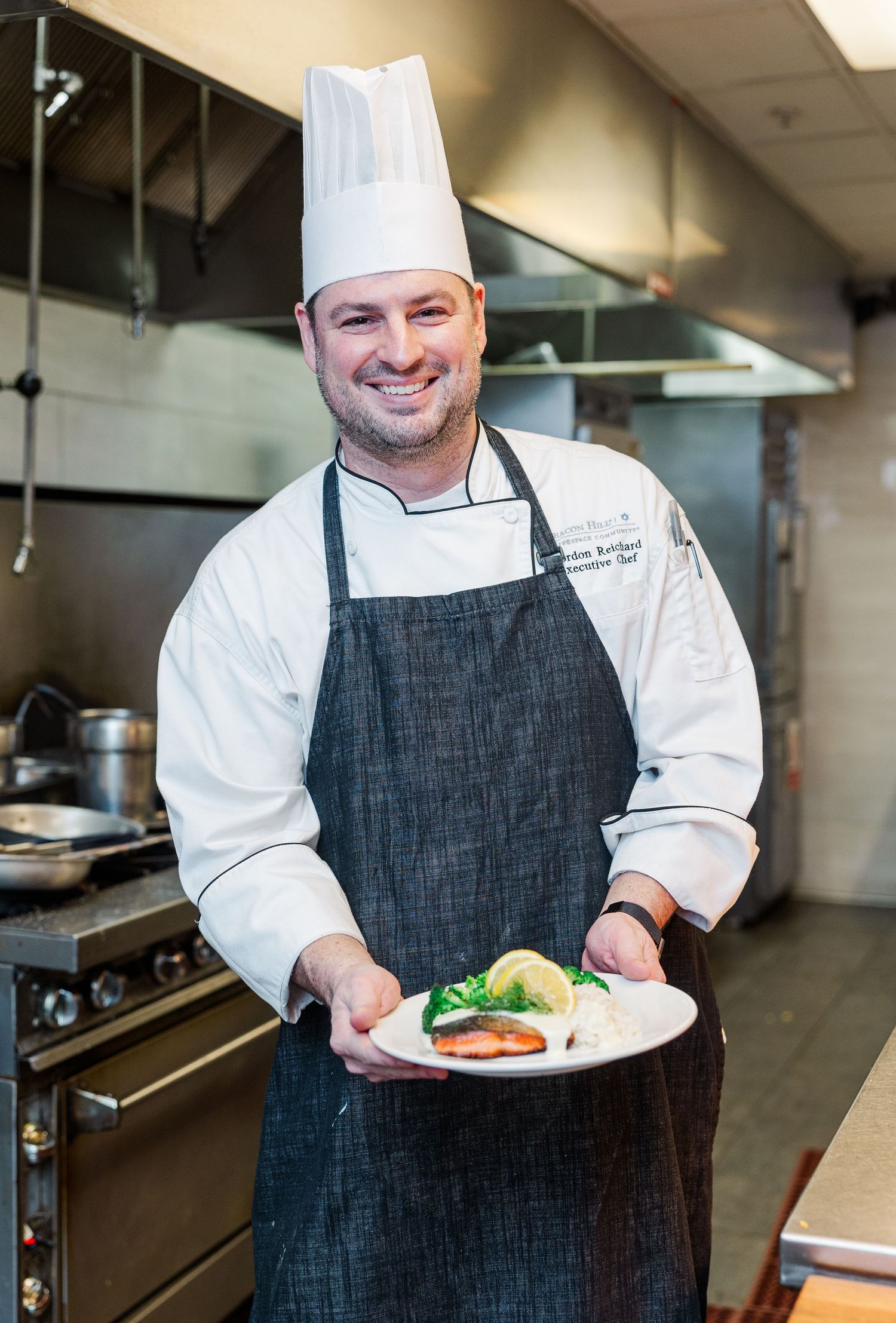 Beacon Hill senior living branding photo in Lombard, Illinois featuring chef holding plated dish