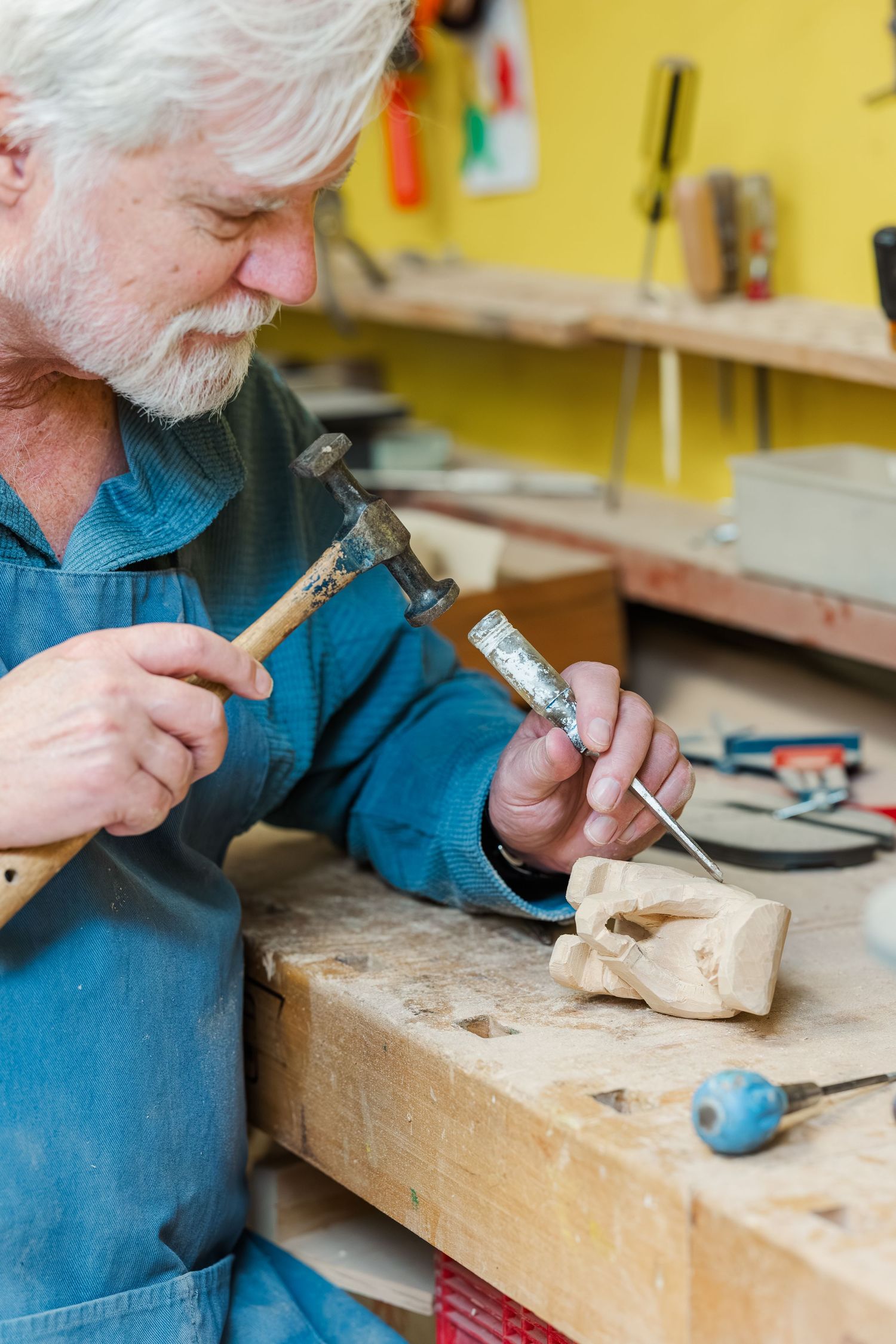 Beacon Hill senior living branding photo in Lombard, Illinois featuring resident carving wood at workbench
