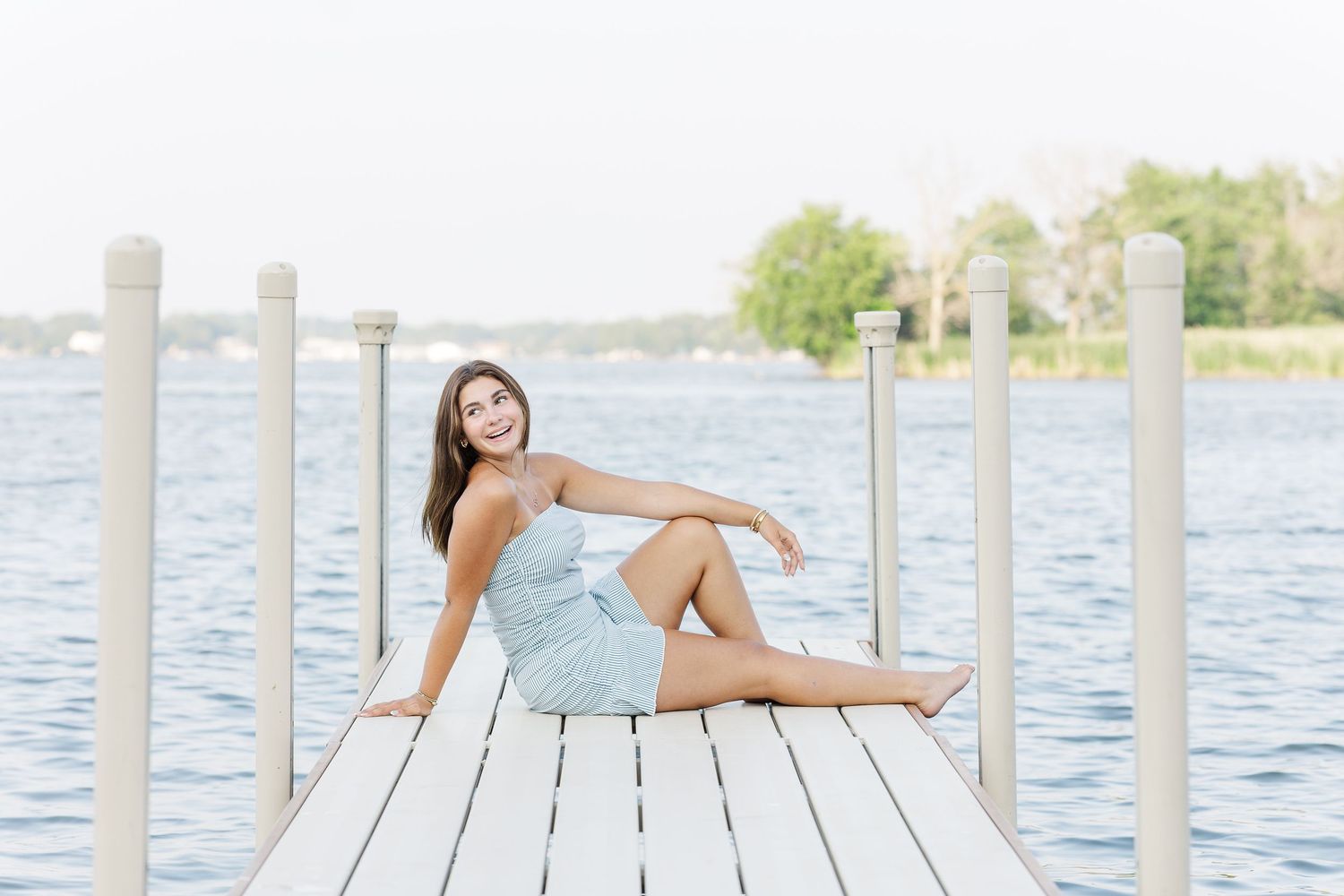 Teen girl posing on dock during Pistakee Lake family photos in Johnsburg, Illinois