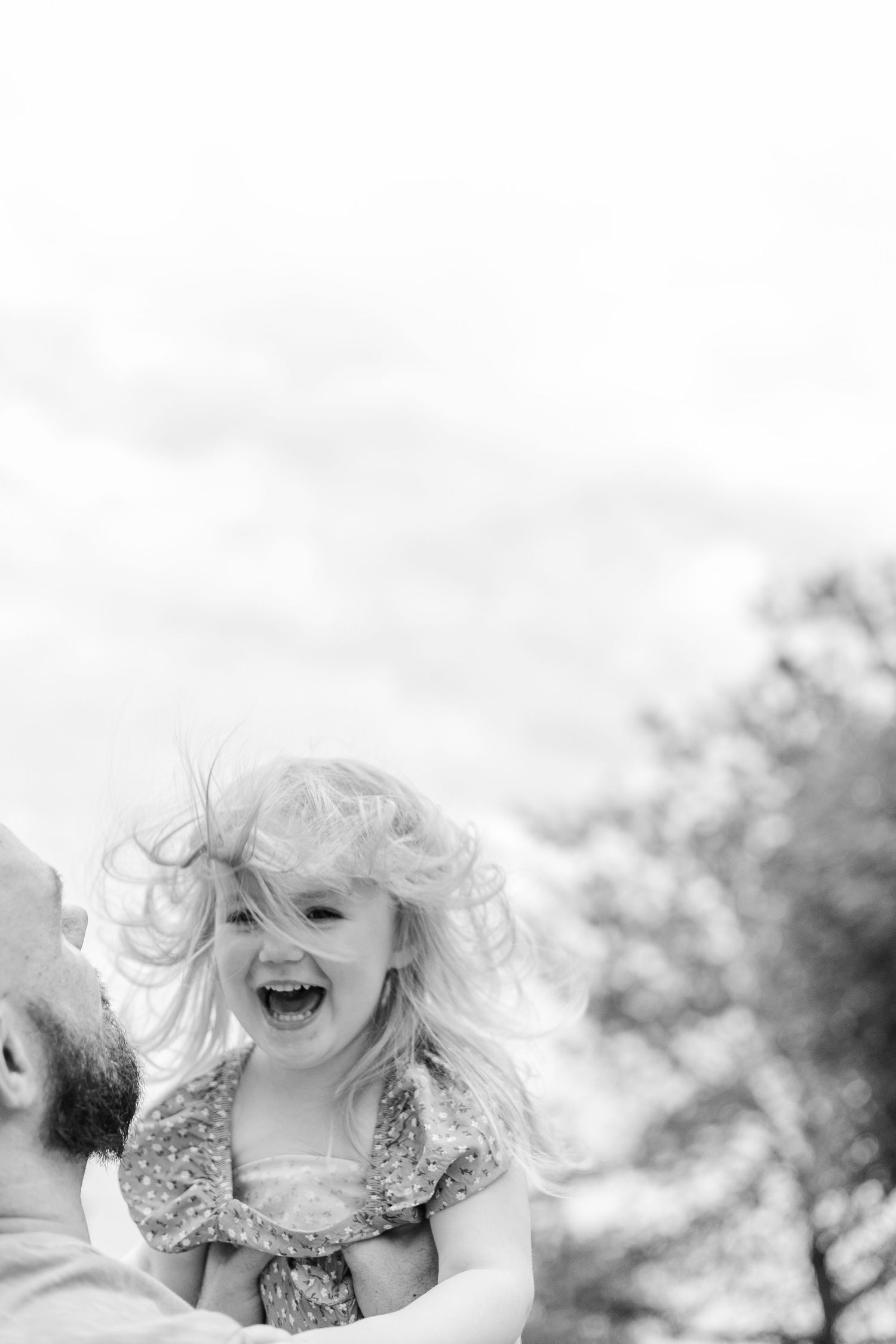 A joyful moment of laughter and play captured in black and white outdoors.