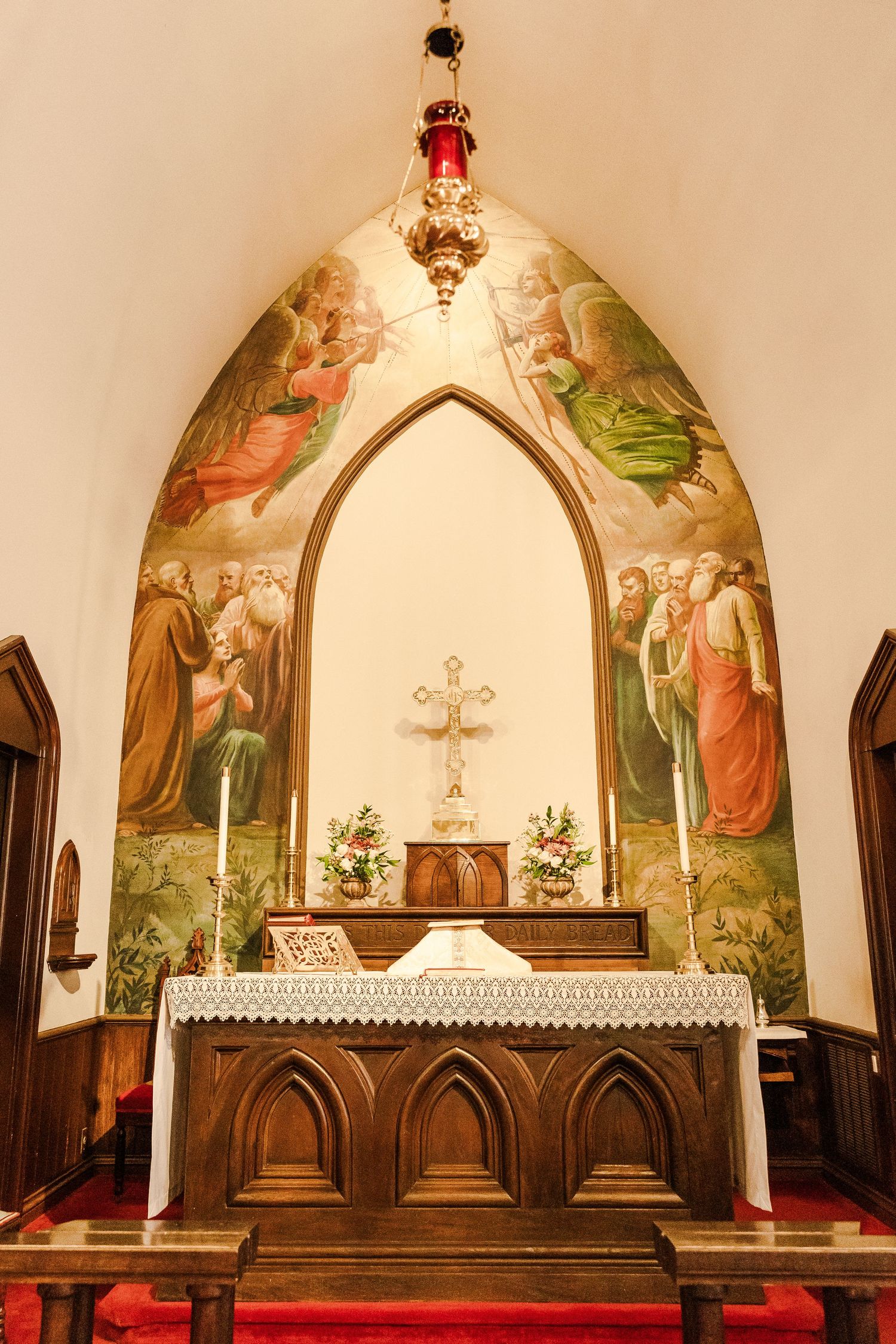 Ornate church altar with religious mural paintings and Gothic arched architecture.